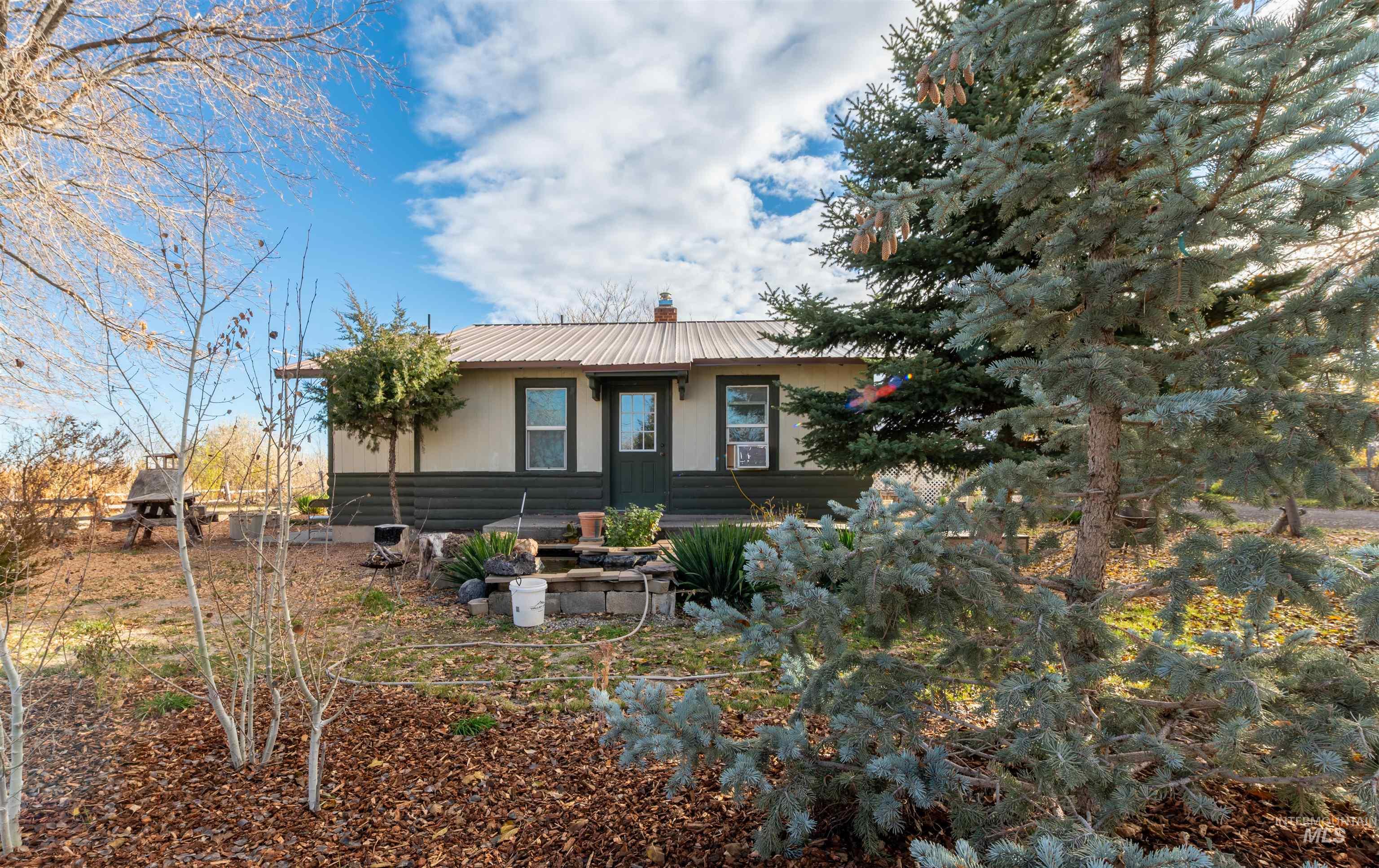 View of front of house featuring a metal roof and a chimney