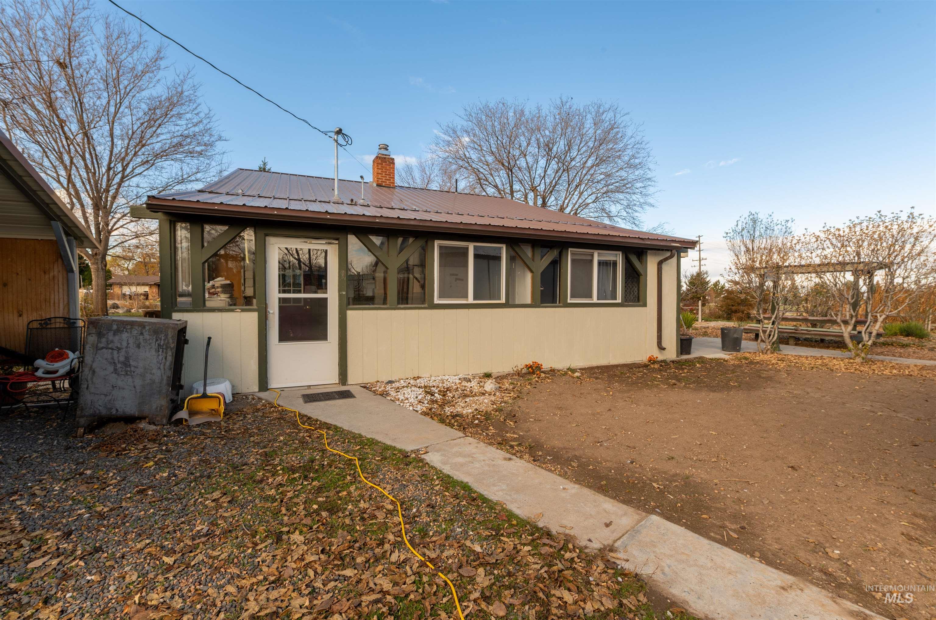 Rear view of property featuring a metal roof and a chimney