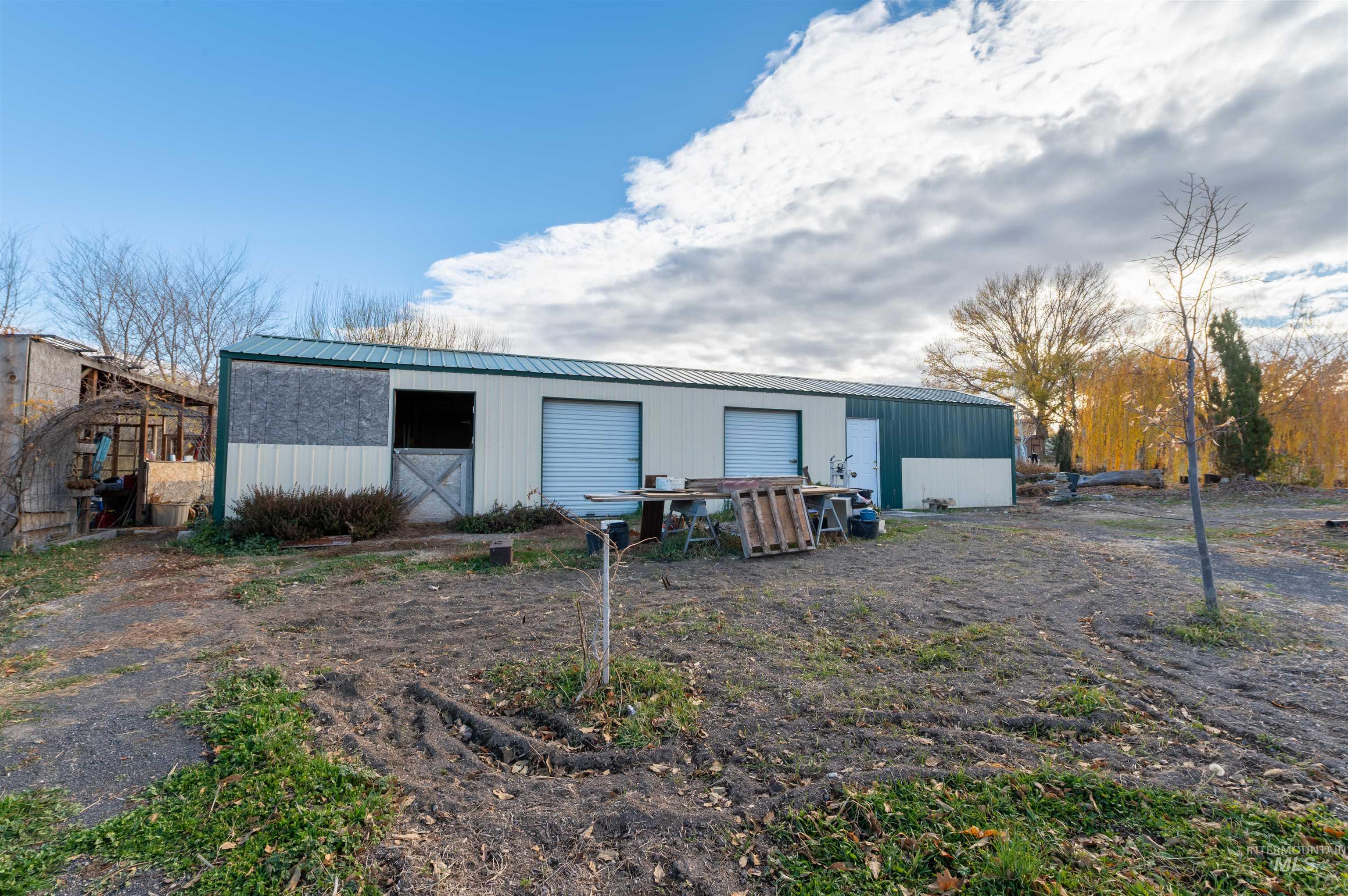 Rear view of house featuring an outbuilding and a metal roof