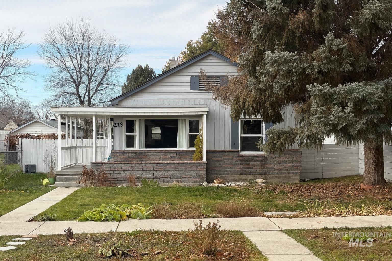 View of front of property featuring brick siding and covered porch