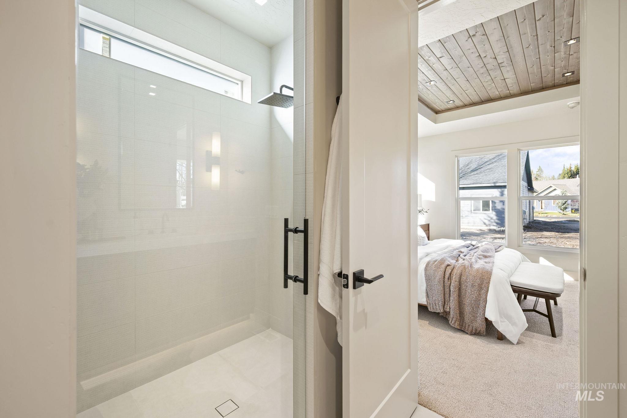 Bathroom with plenty of natural light, ensuite bath, a shower stall, carpet, and wooden ceiling