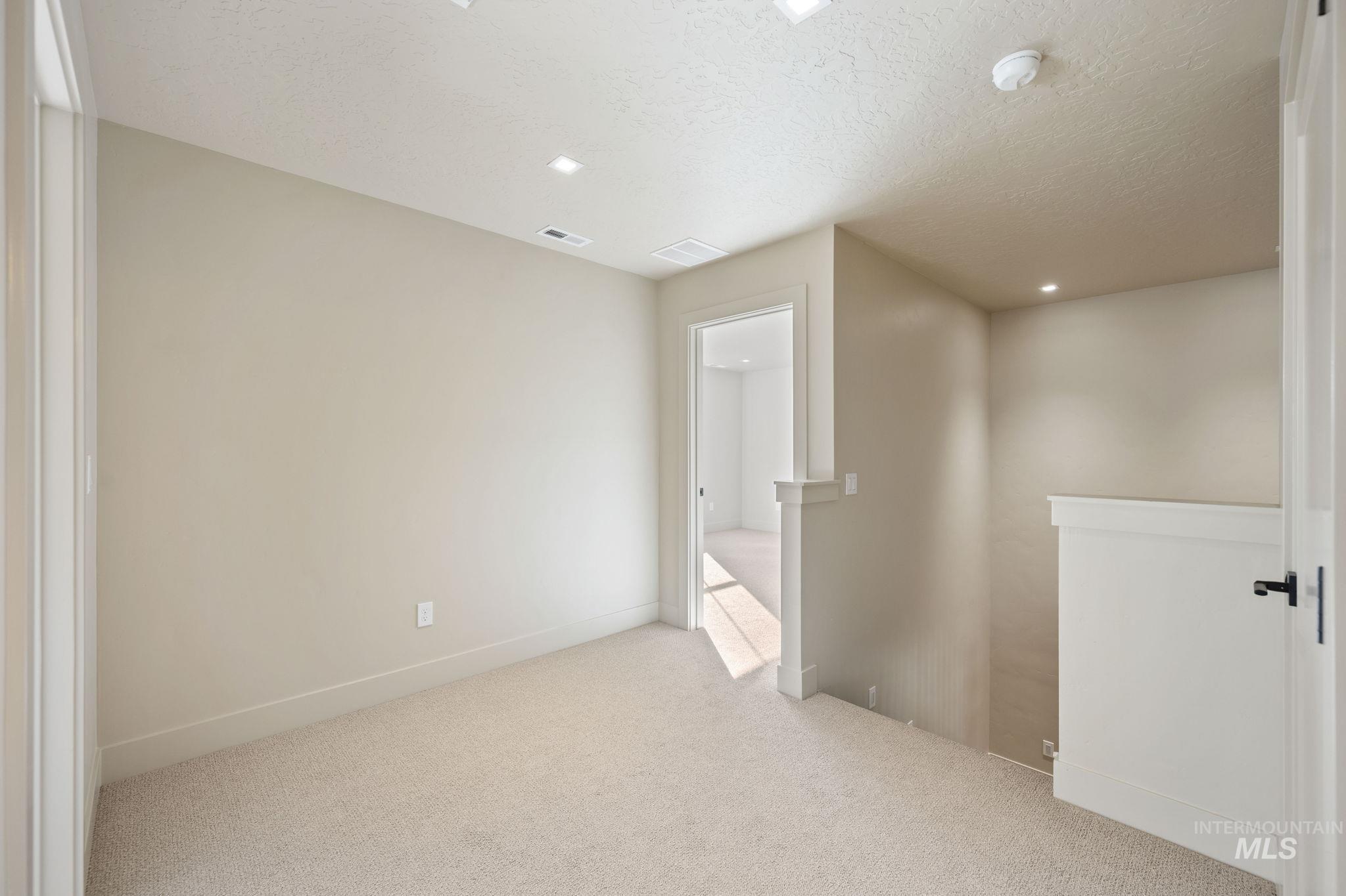 Unfurnished bedroom with carpet, a textured ceiling, and recessed lighting