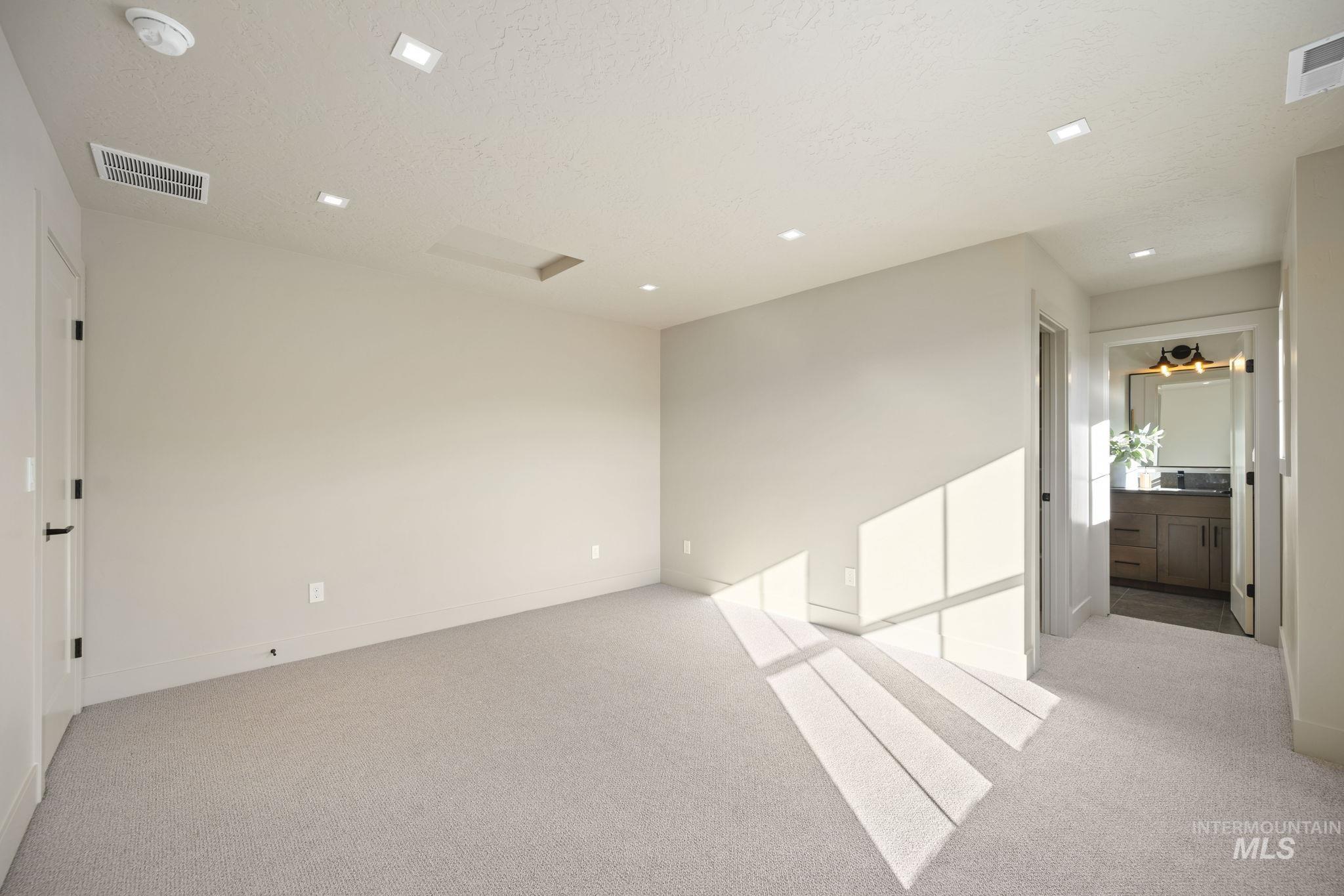Spare room featuring light colored carpet, attic access, and recessed lighting