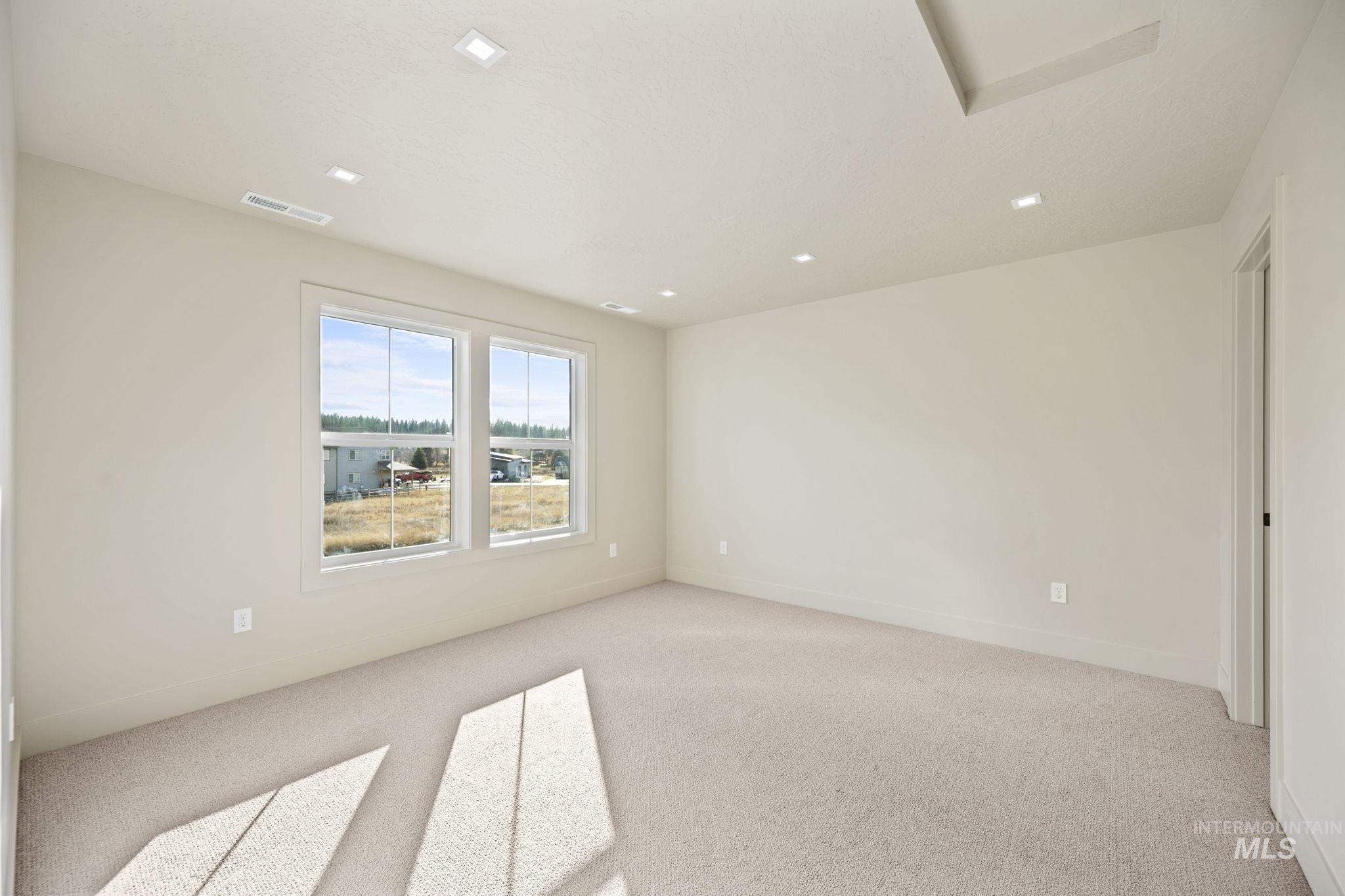 Empty room with light carpet and baseboards