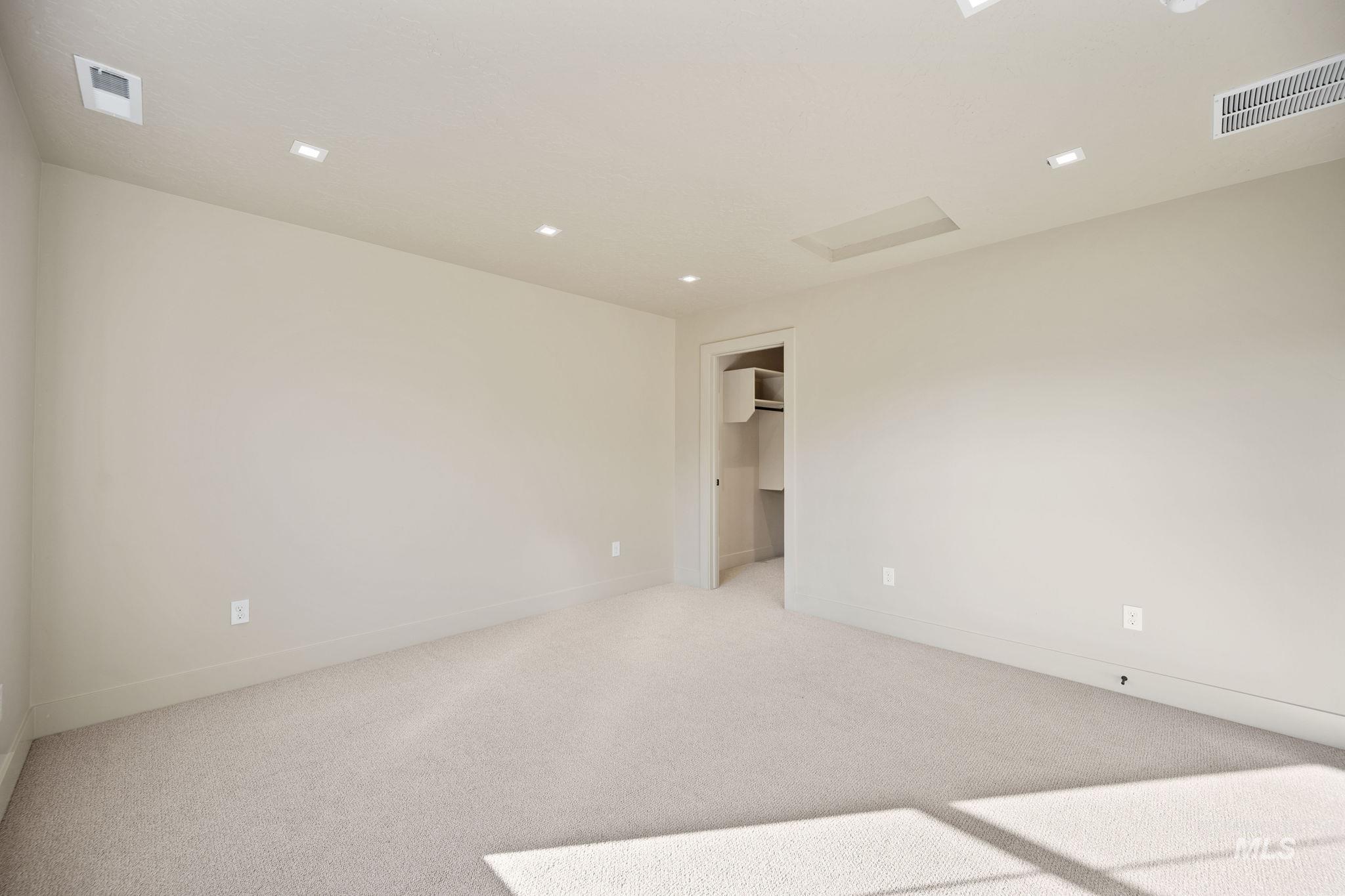 Spare room featuring light carpet and attic access