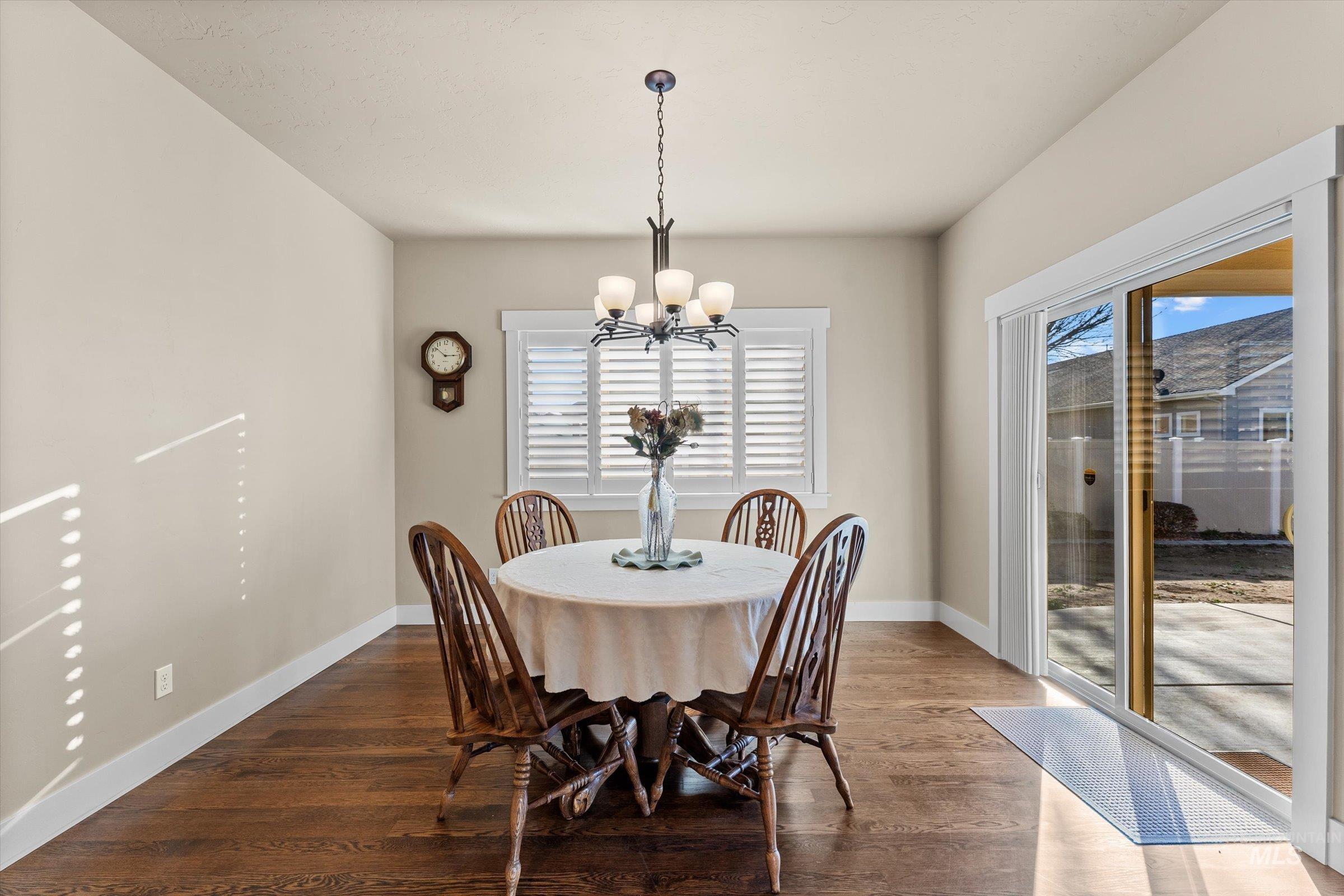 Dining room with dark wood-style flooring and a chandelier