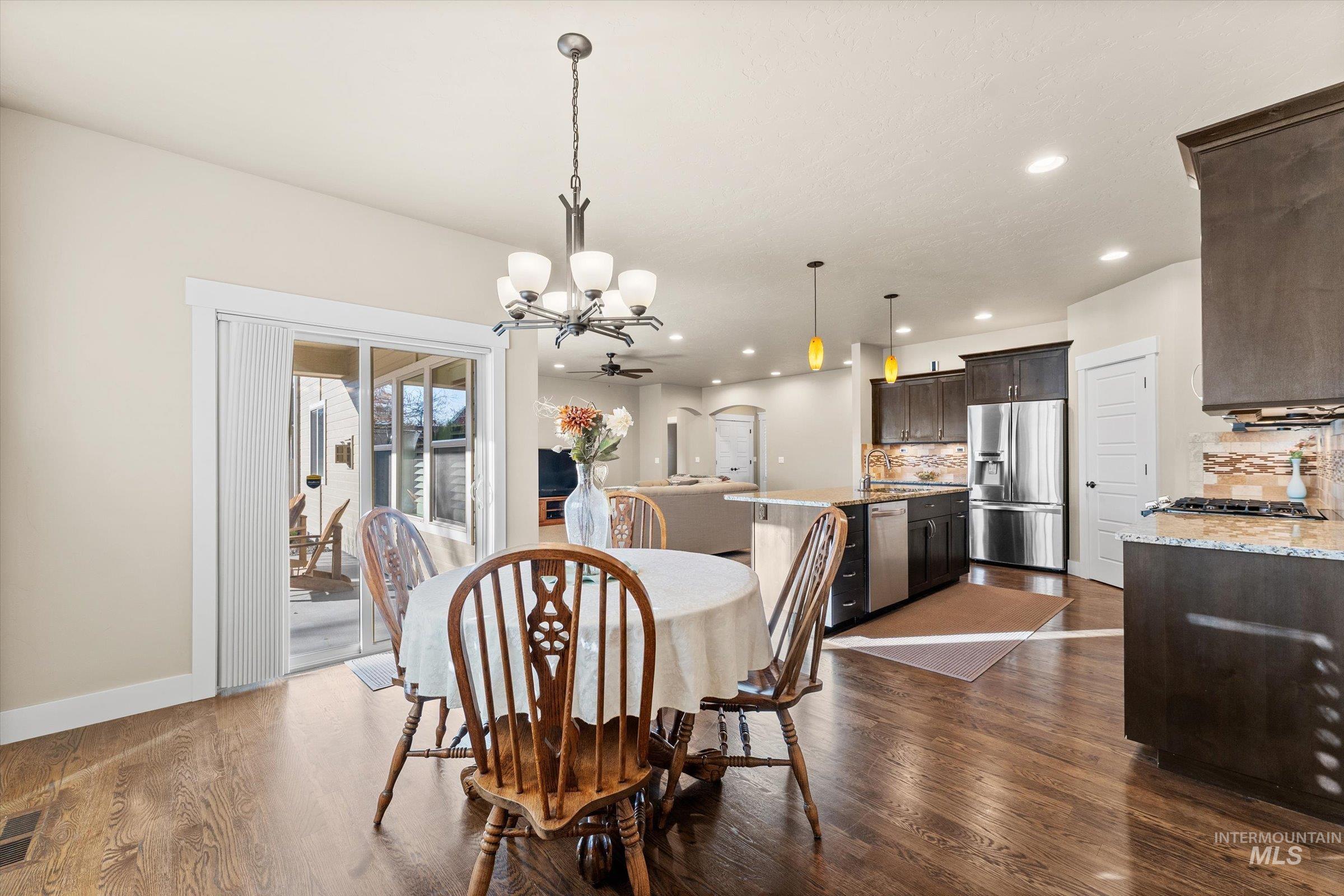 Dining area with recessed lighting, dark wood-style flooring, and a chandelier