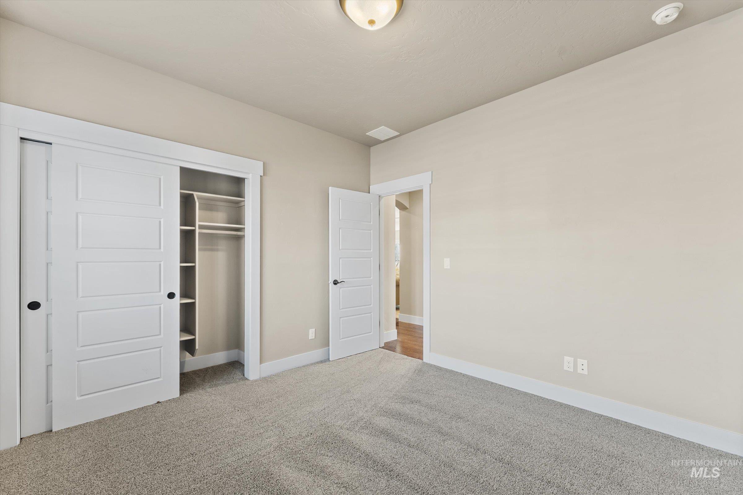 Unfurnished bedroom featuring light colored carpet and a closet