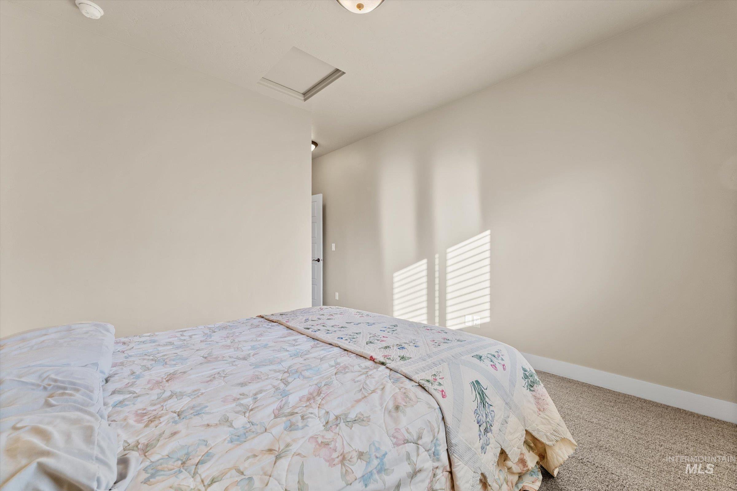 Bedroom featuring carpet flooring and attic access