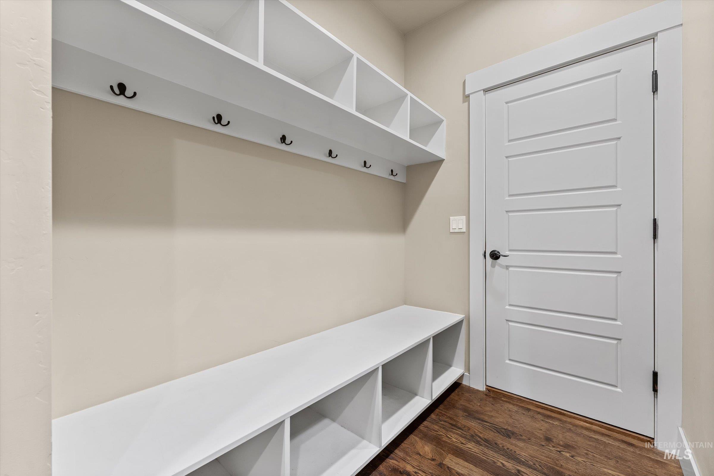 Mudroom with dark wood-style flooring and baseboards