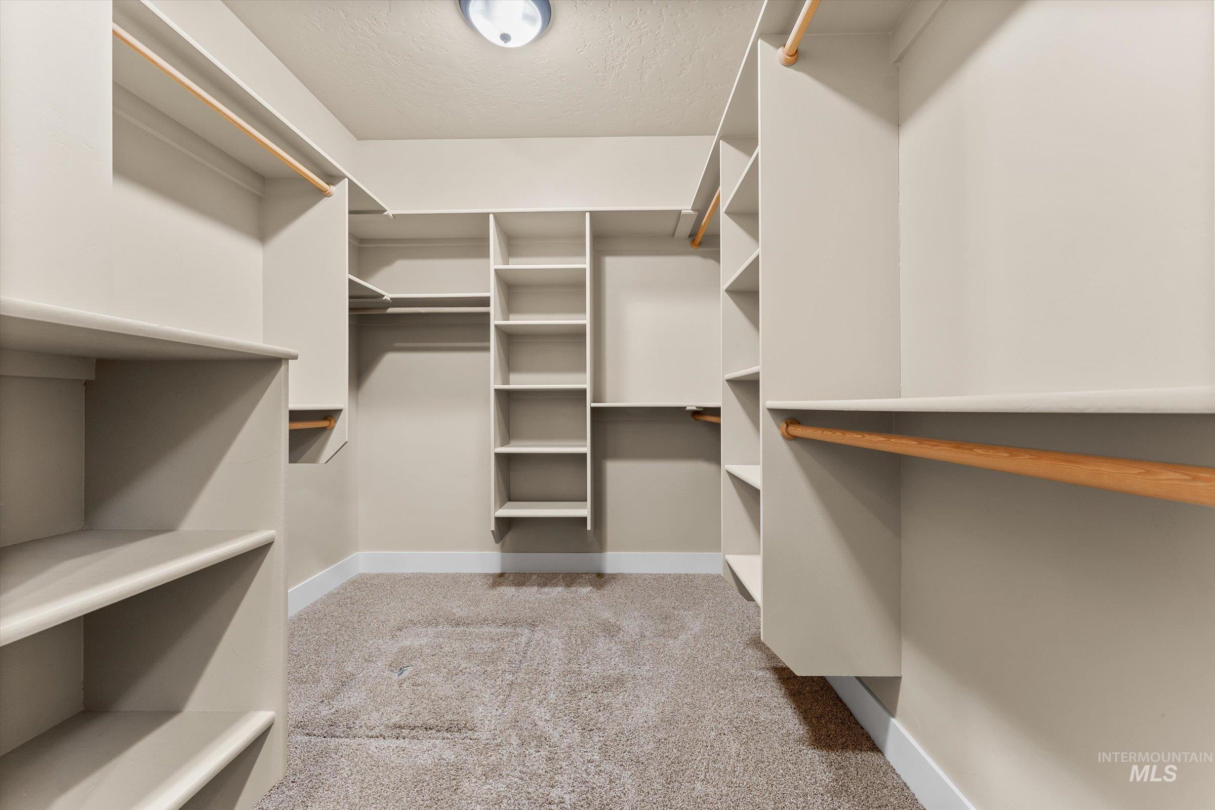 Spacious closet with light colored carpet