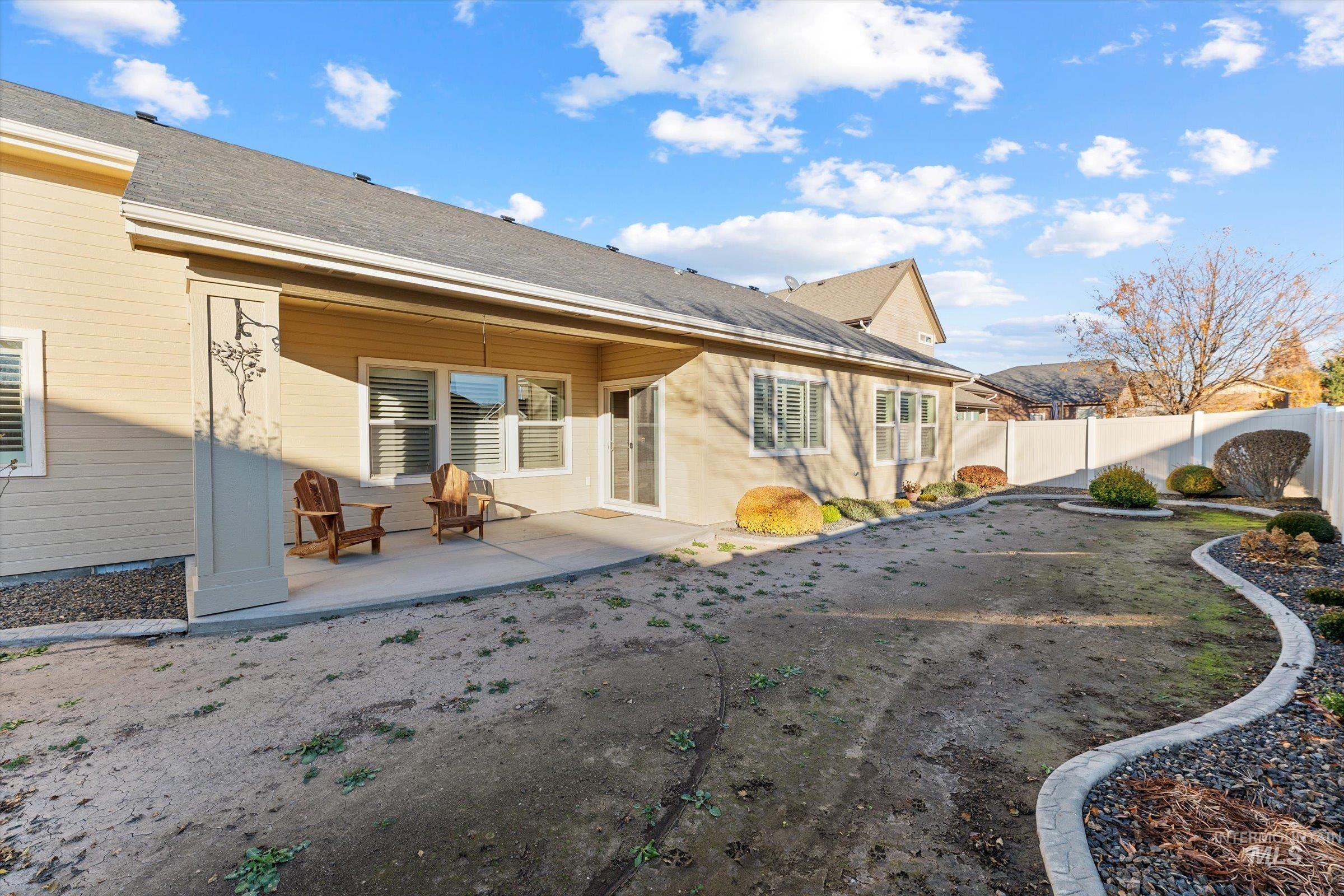 Back of house featuring a patio, a fenced backyard, and roof with shingles
