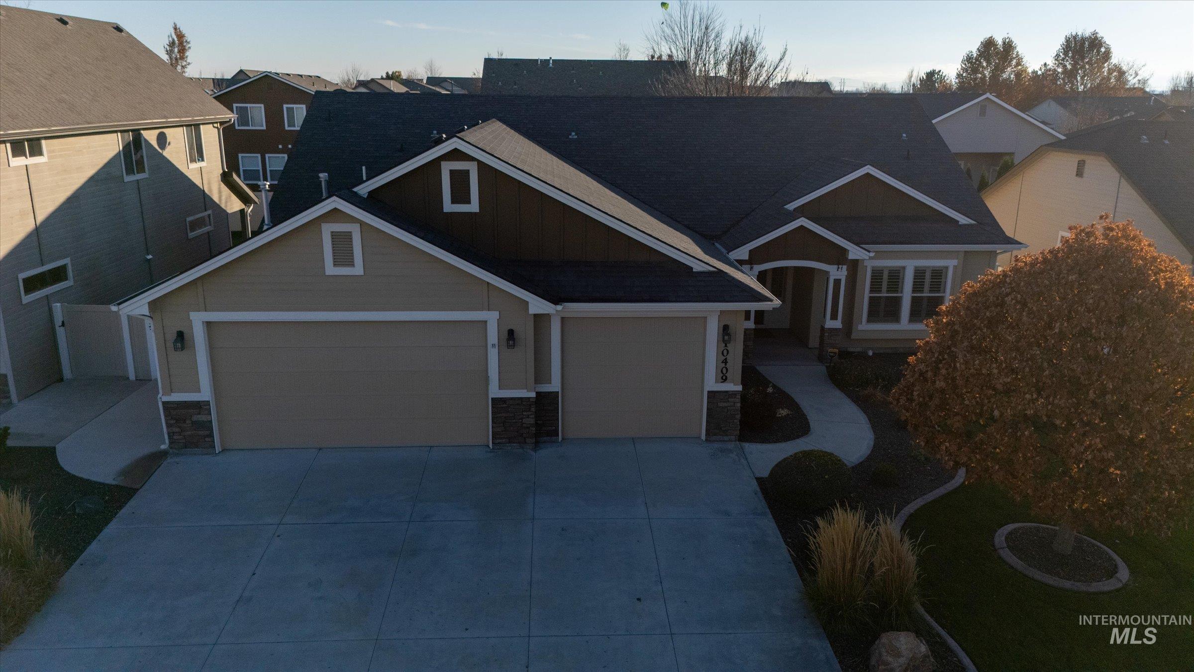 View of front of property with stone siding, concrete driveway, and an attached garage