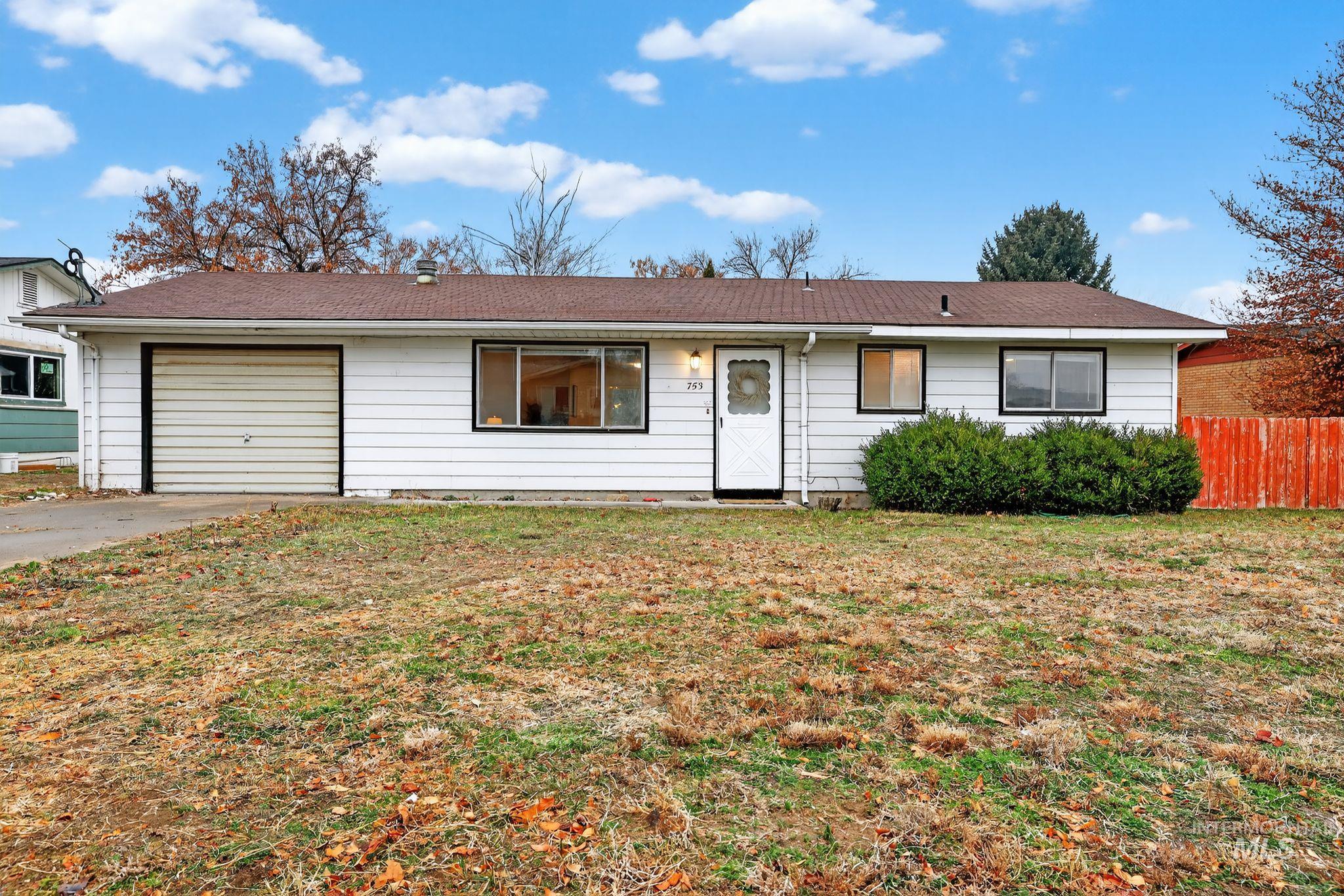 Ranch-style house featuring driveway, an attached garage, and a shingled roof