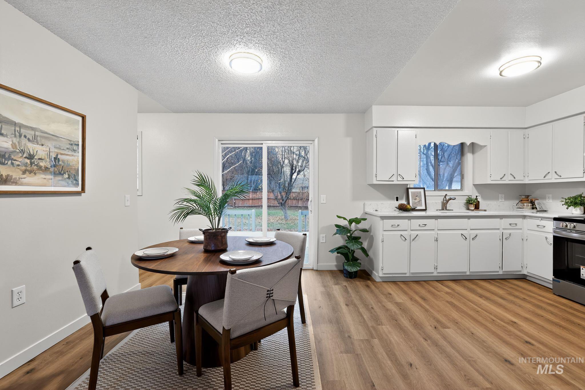 Dining area with a textured ceiling and light wood-style floors
