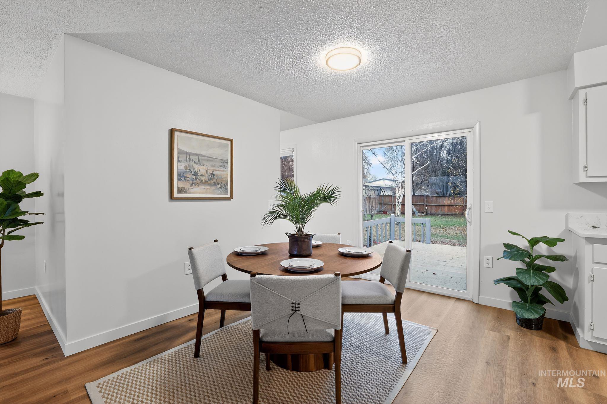 Dining area featuring a textured ceiling and light wood finished floors