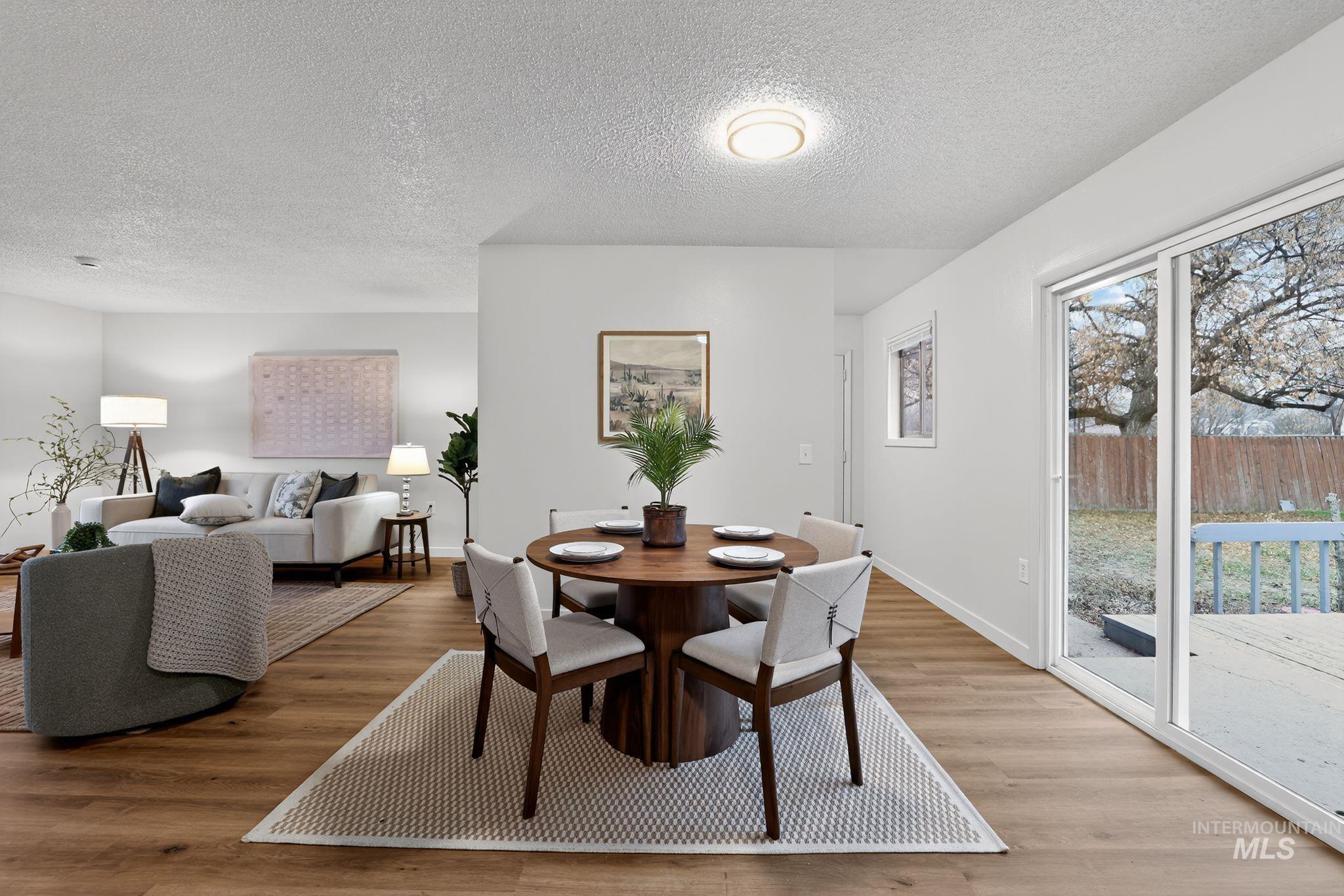 Dining space featuring a textured ceiling and light wood-style flooring
