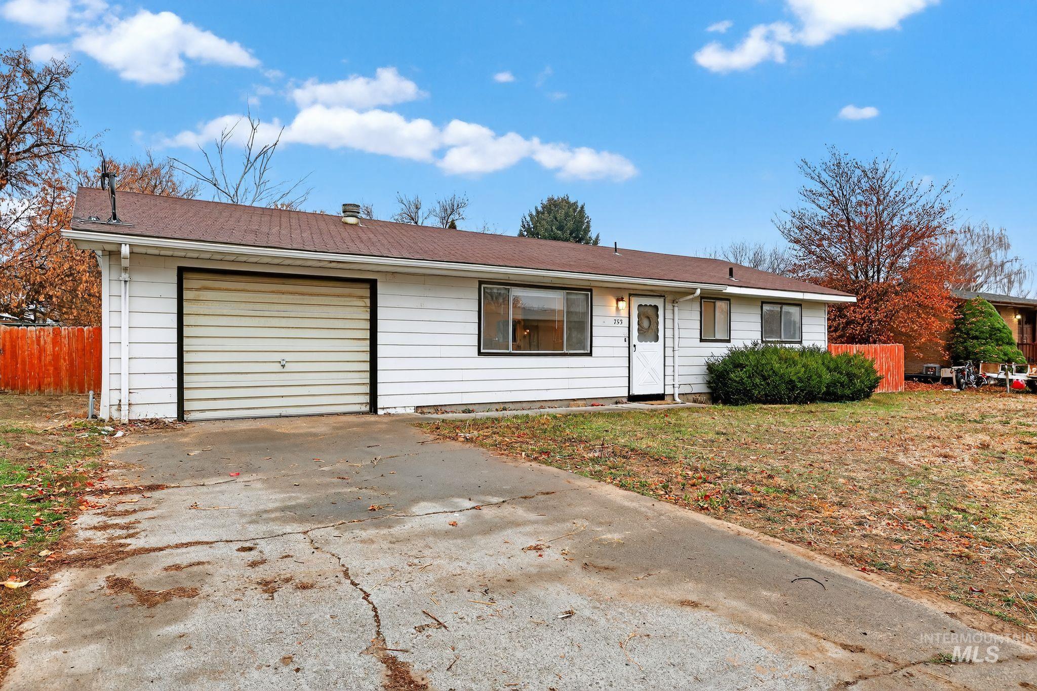 Ranch-style house with driveway, a garage, and a shingled roof