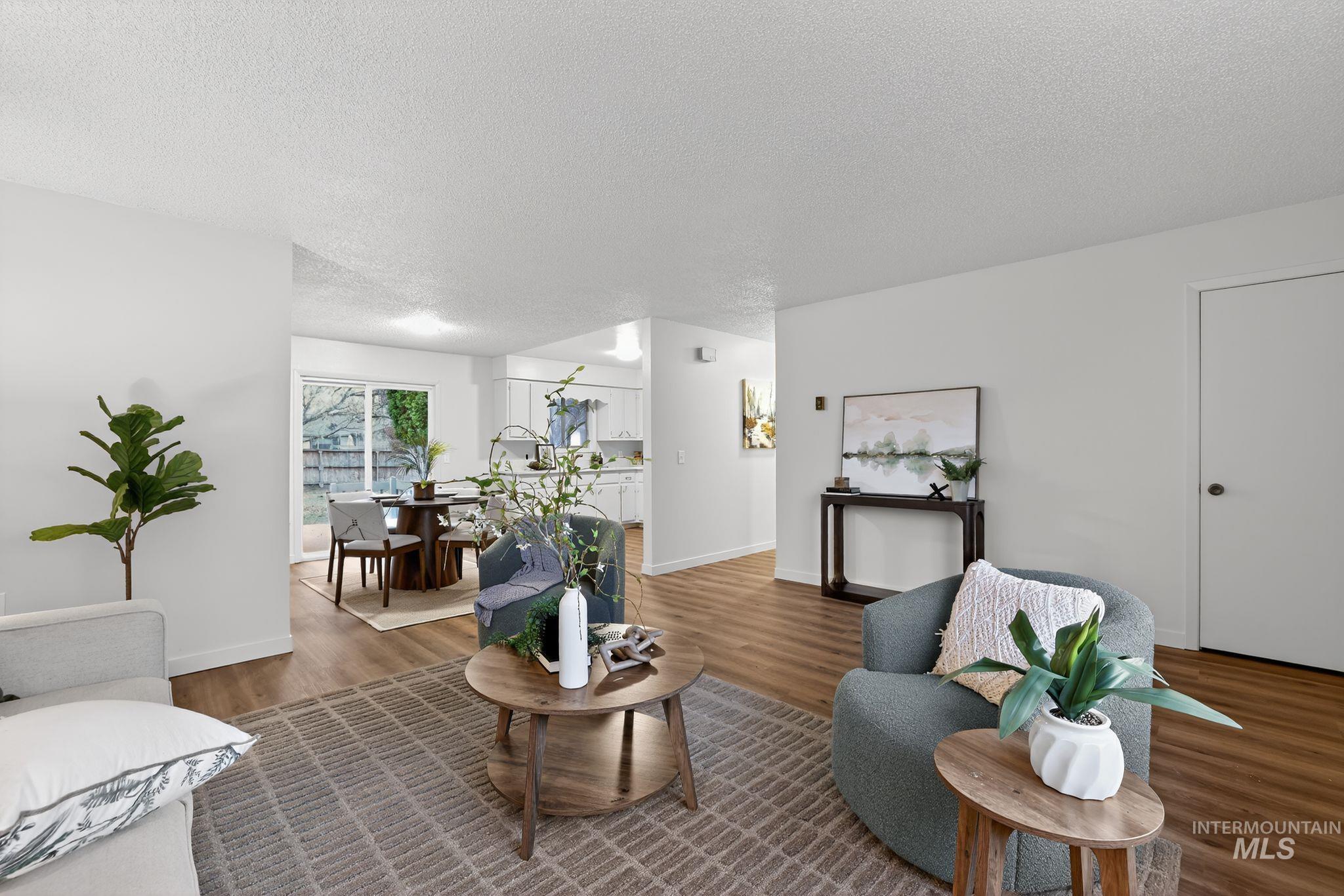 Living room with a textured ceiling and wood finished floors