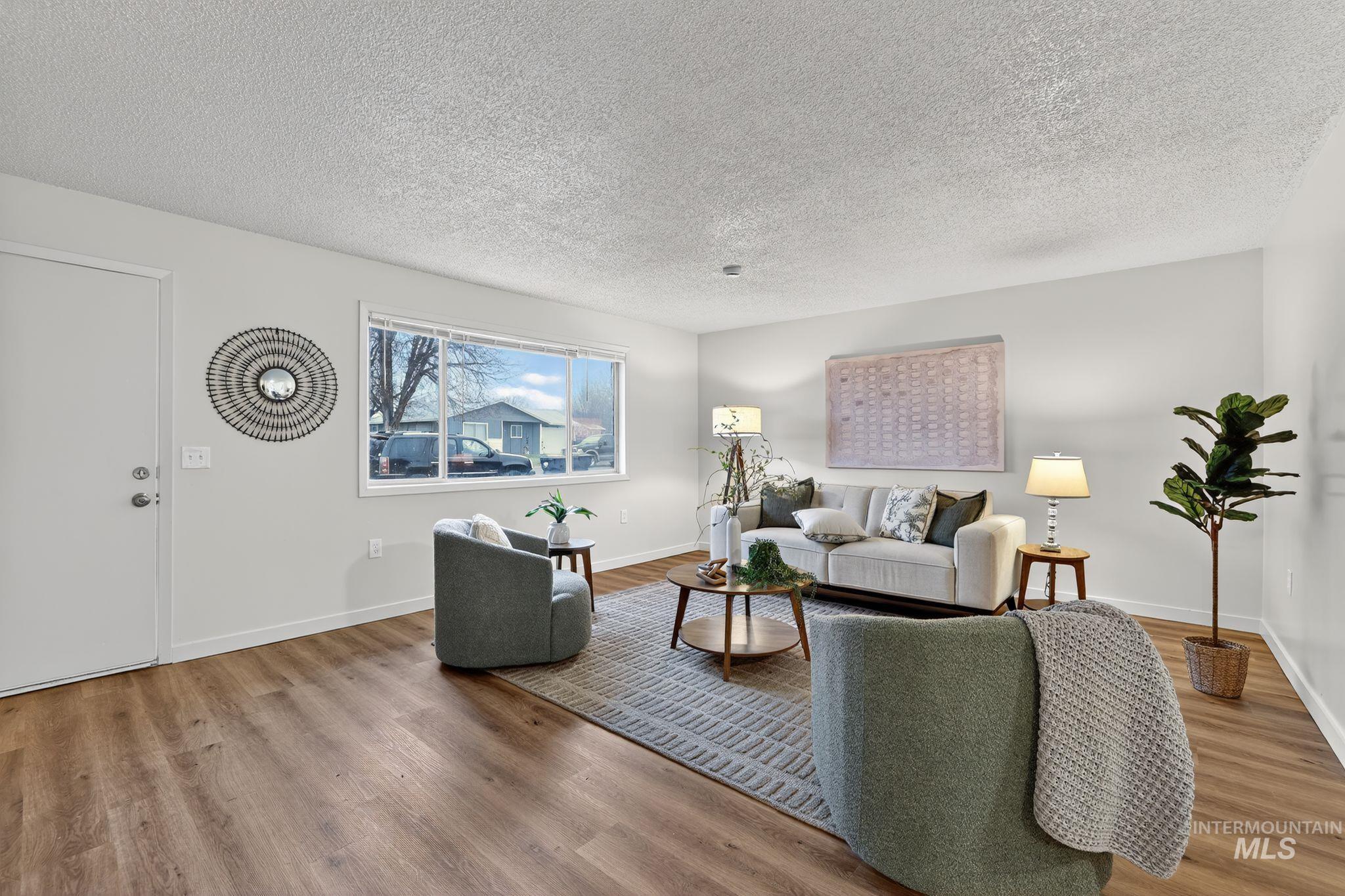 Living room featuring a textured ceiling and light wood-type flooring