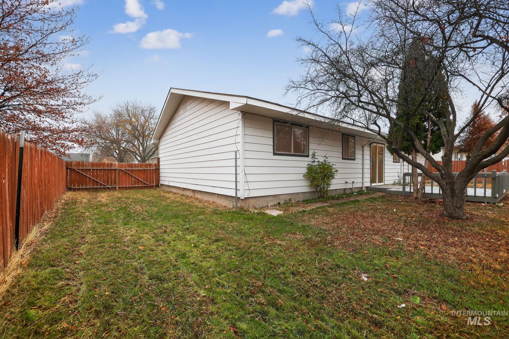 View of side of property with a fenced backyard and a gate