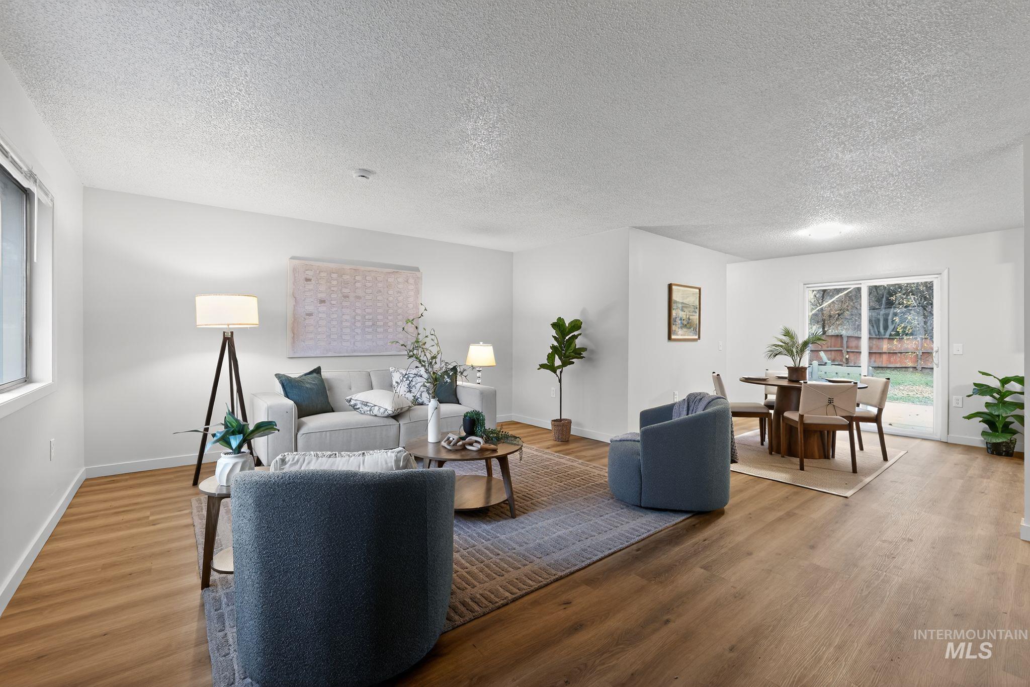 Living room with a textured ceiling and light wood-type flooring