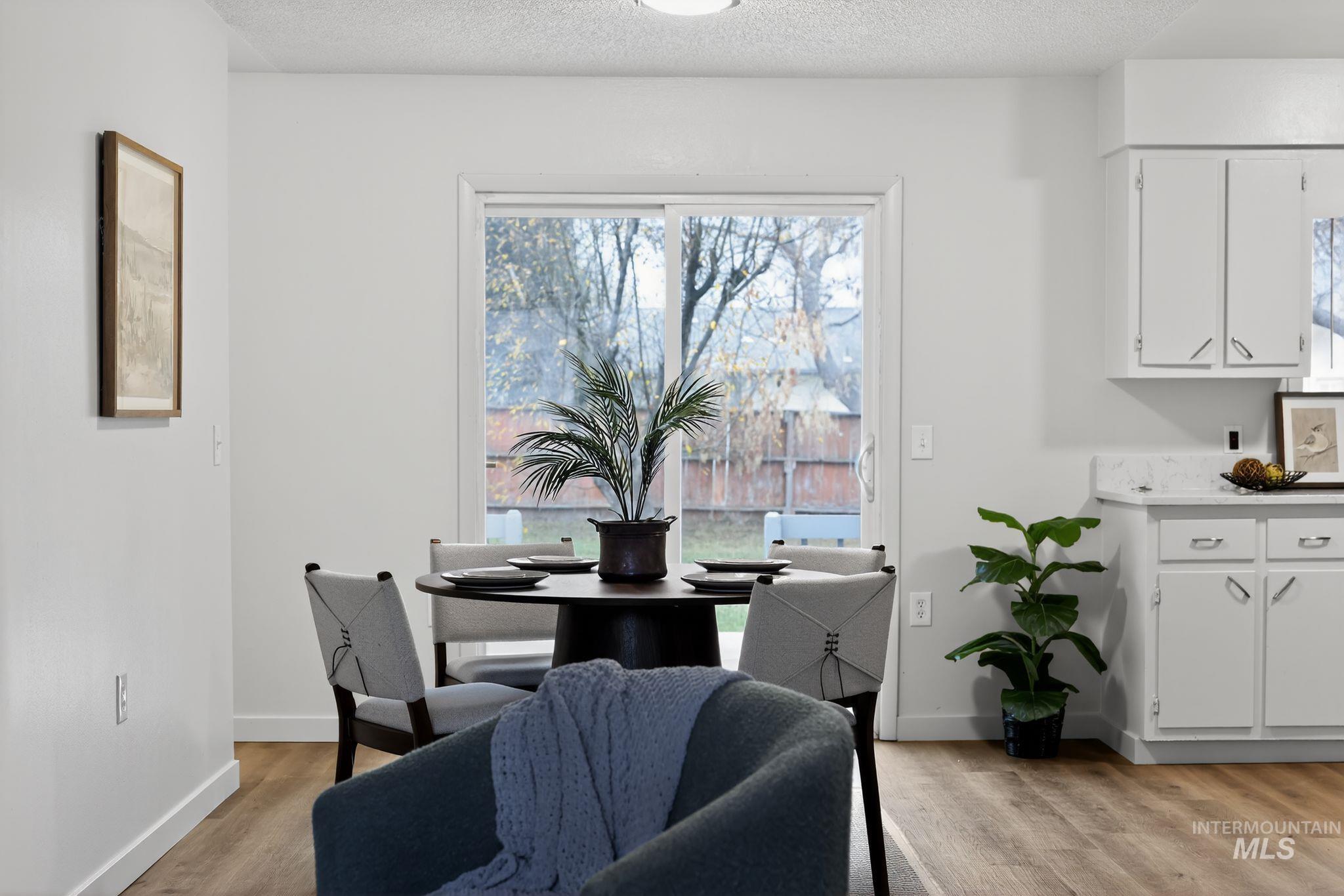 Dining area with light wood finished floors and a textured ceiling