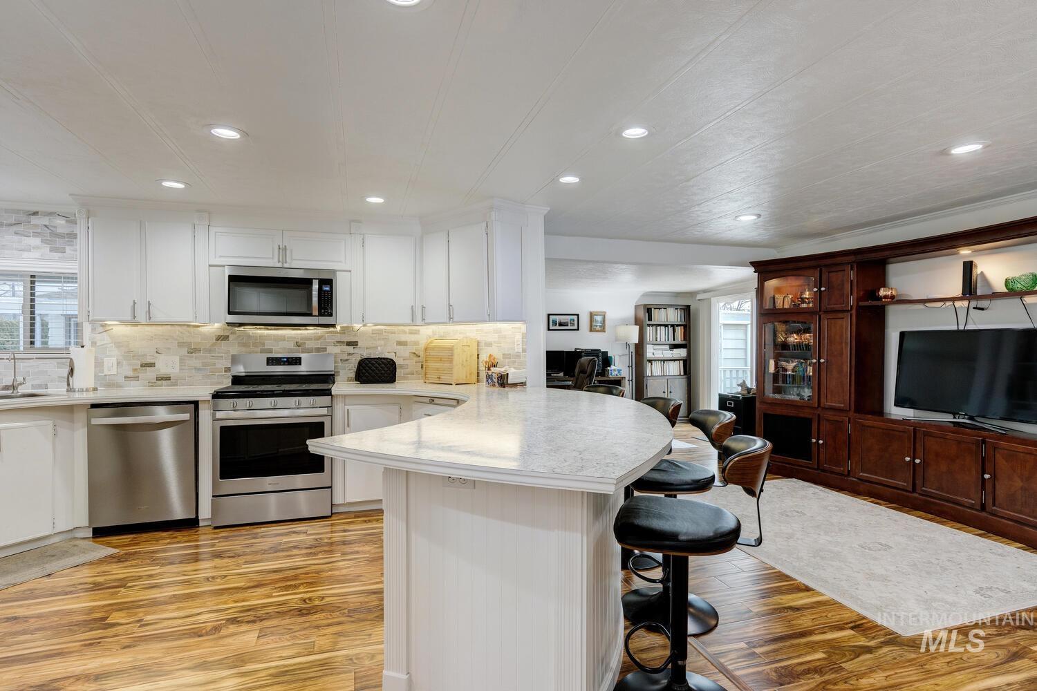 Kitchen featuring a breakfast bar, stainless steel appliances, plenty of natural light, a peninsula, and recessed lighting