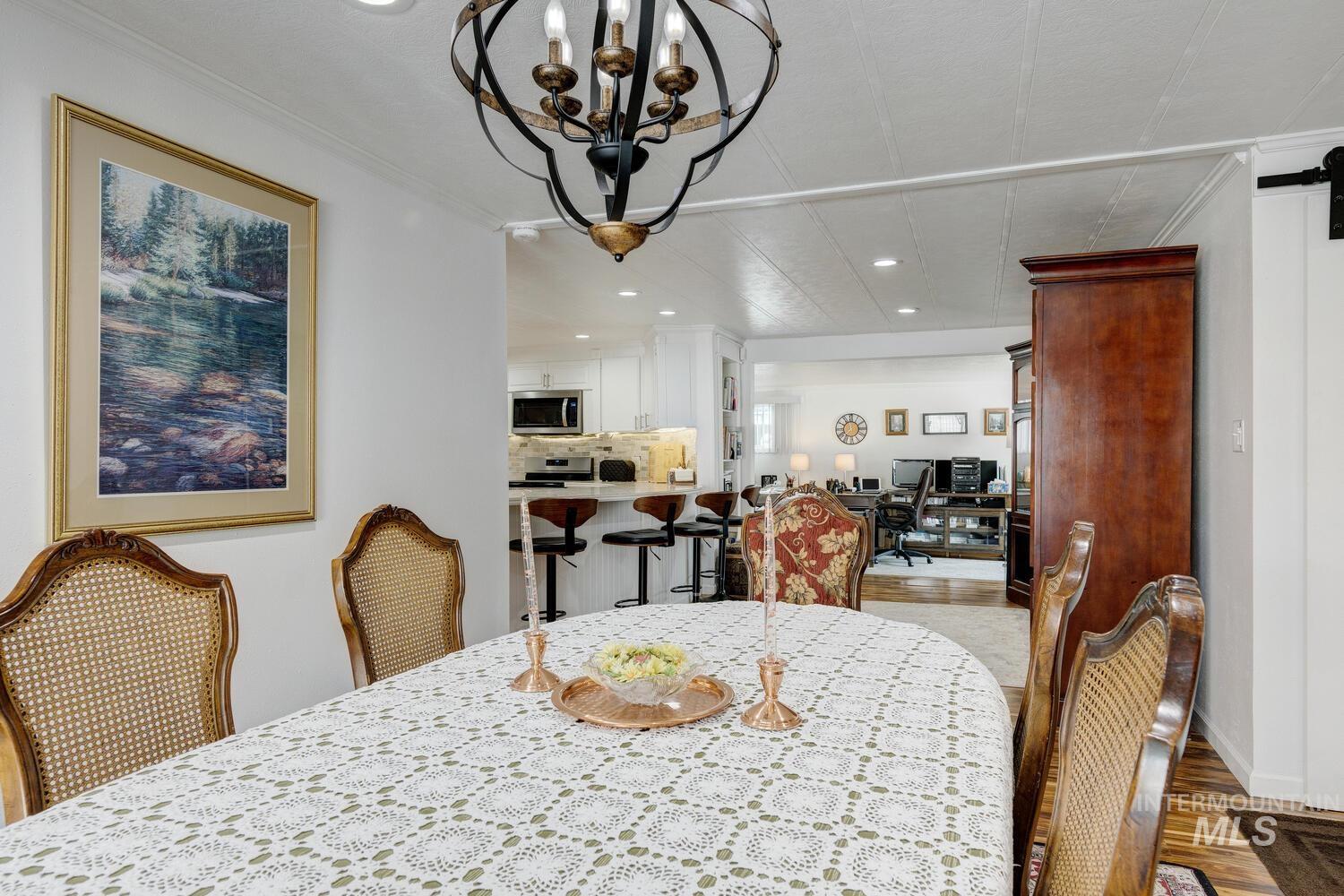 Dining area featuring recessed lighting, light wood-style flooring, crown molding, a desk, and a chandelier
