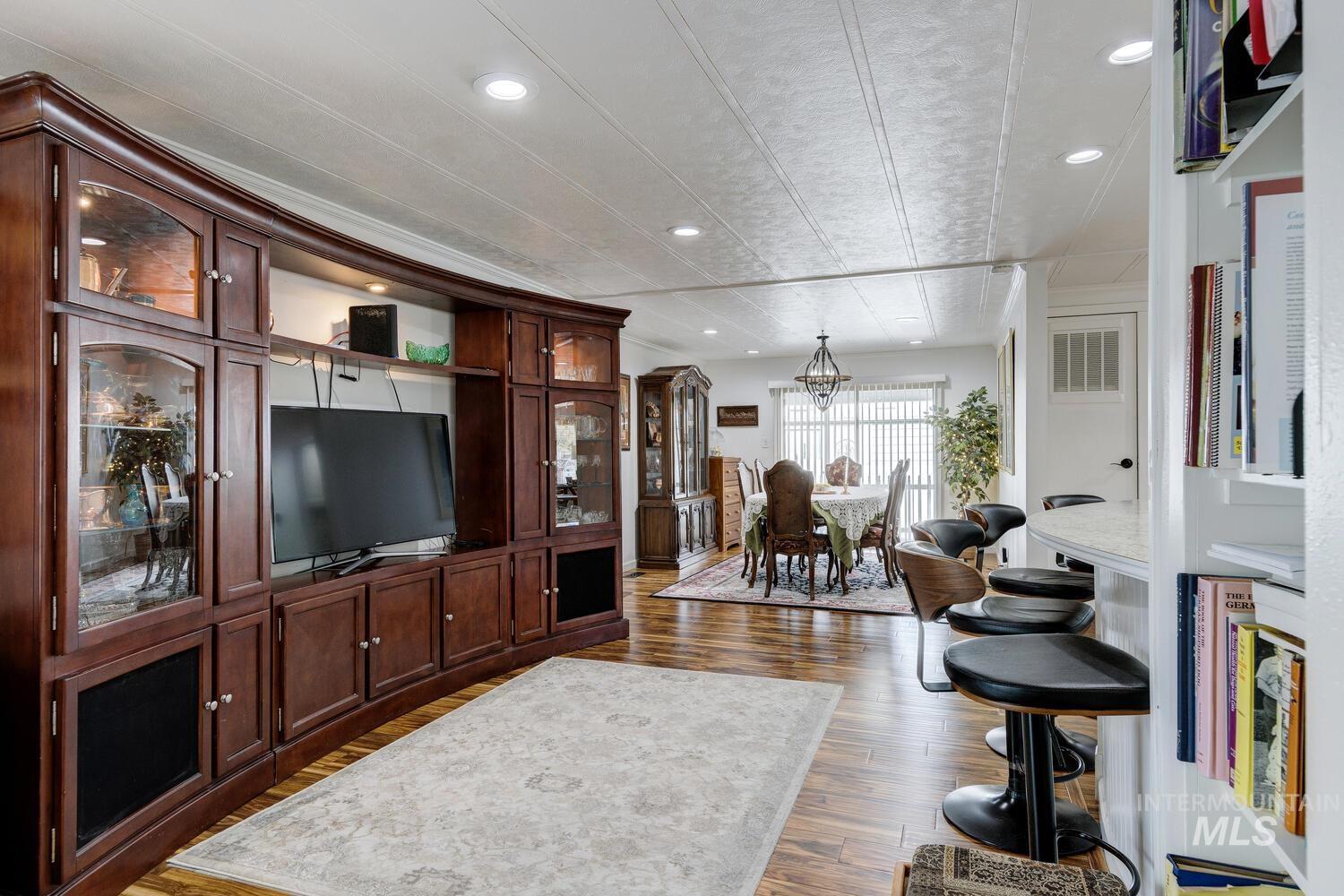 Living area with recessed lighting and dark wood-style floors