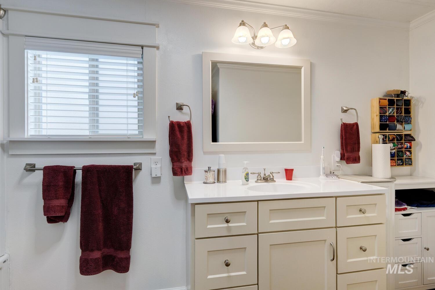 Bathroom with vanity and ornamental molding