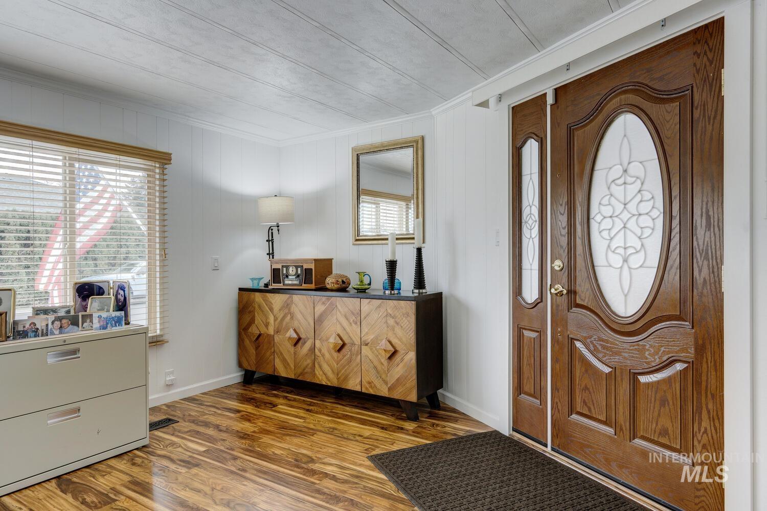 Foyer entrance with dark wood-type flooring and baseboards