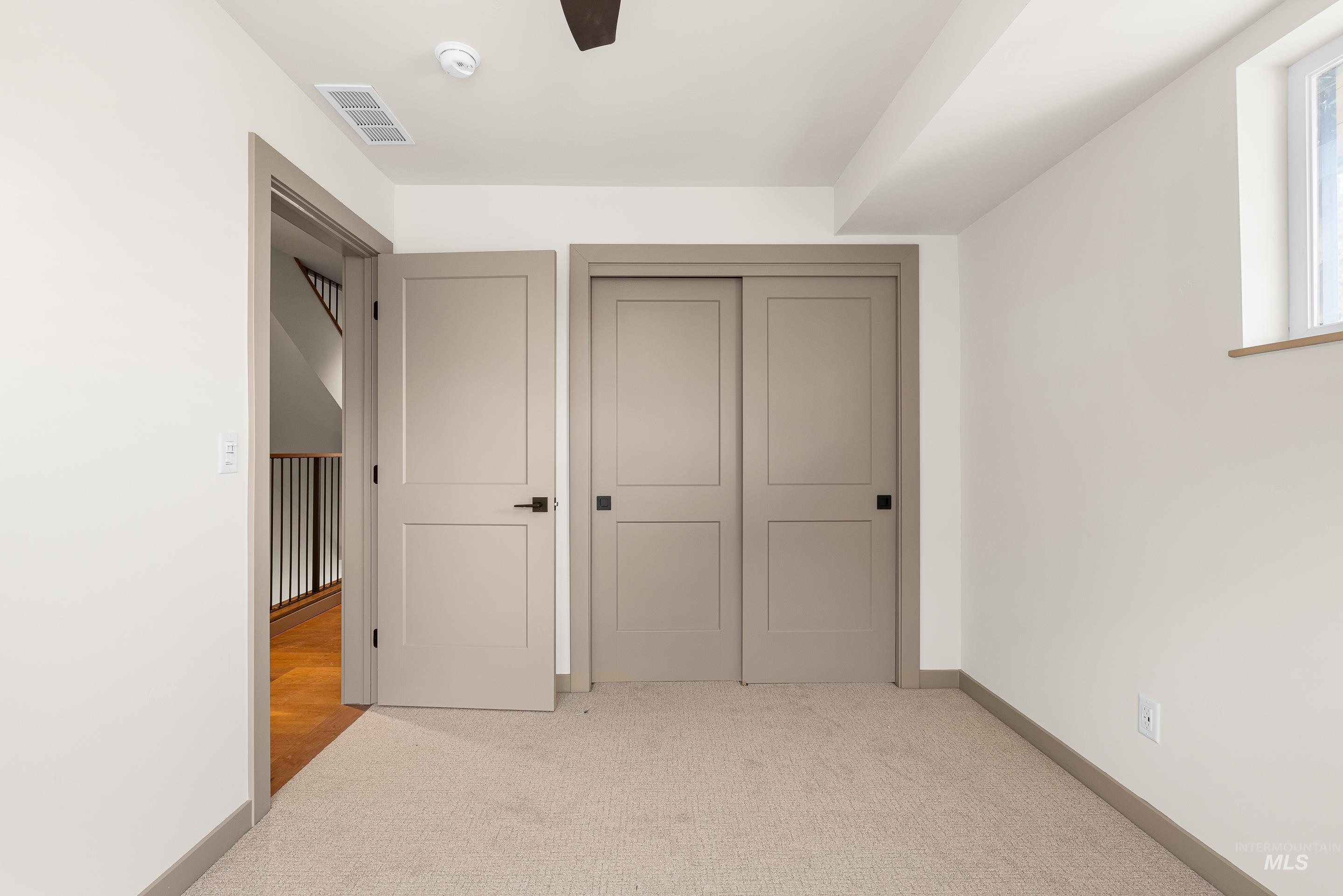 Unfurnished bedroom with light colored carpet and a closet