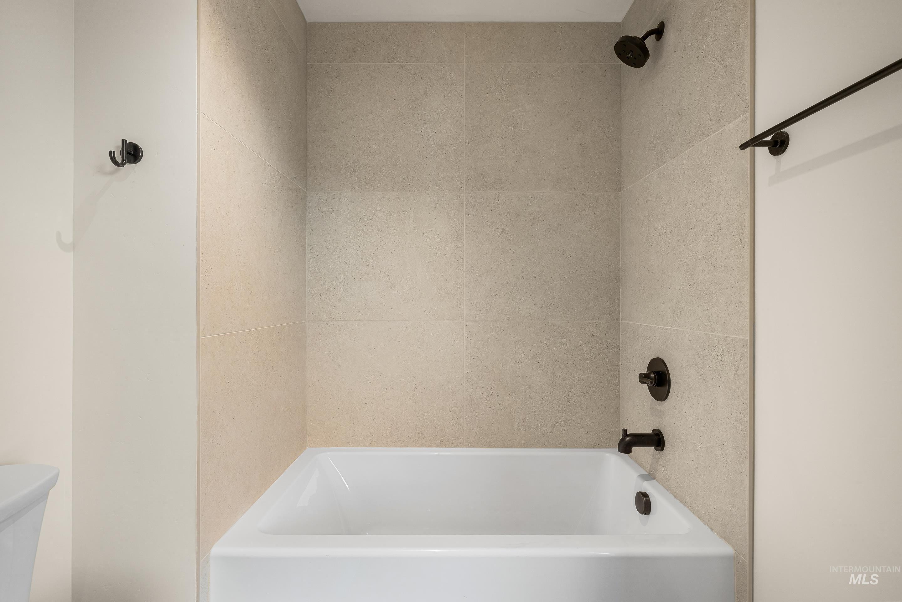 Full bath featuring toilet and washtub / shower combination