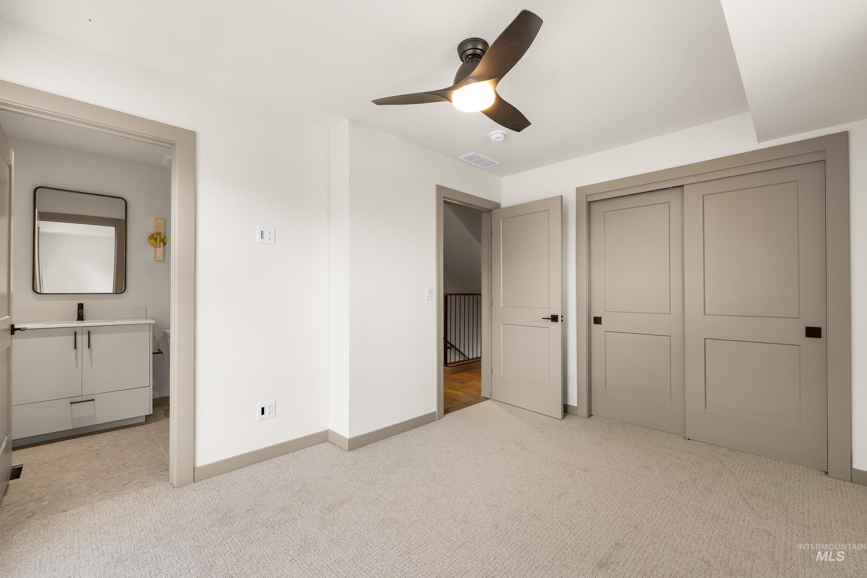 Unfurnished bedroom featuring light carpet and ceiling fan