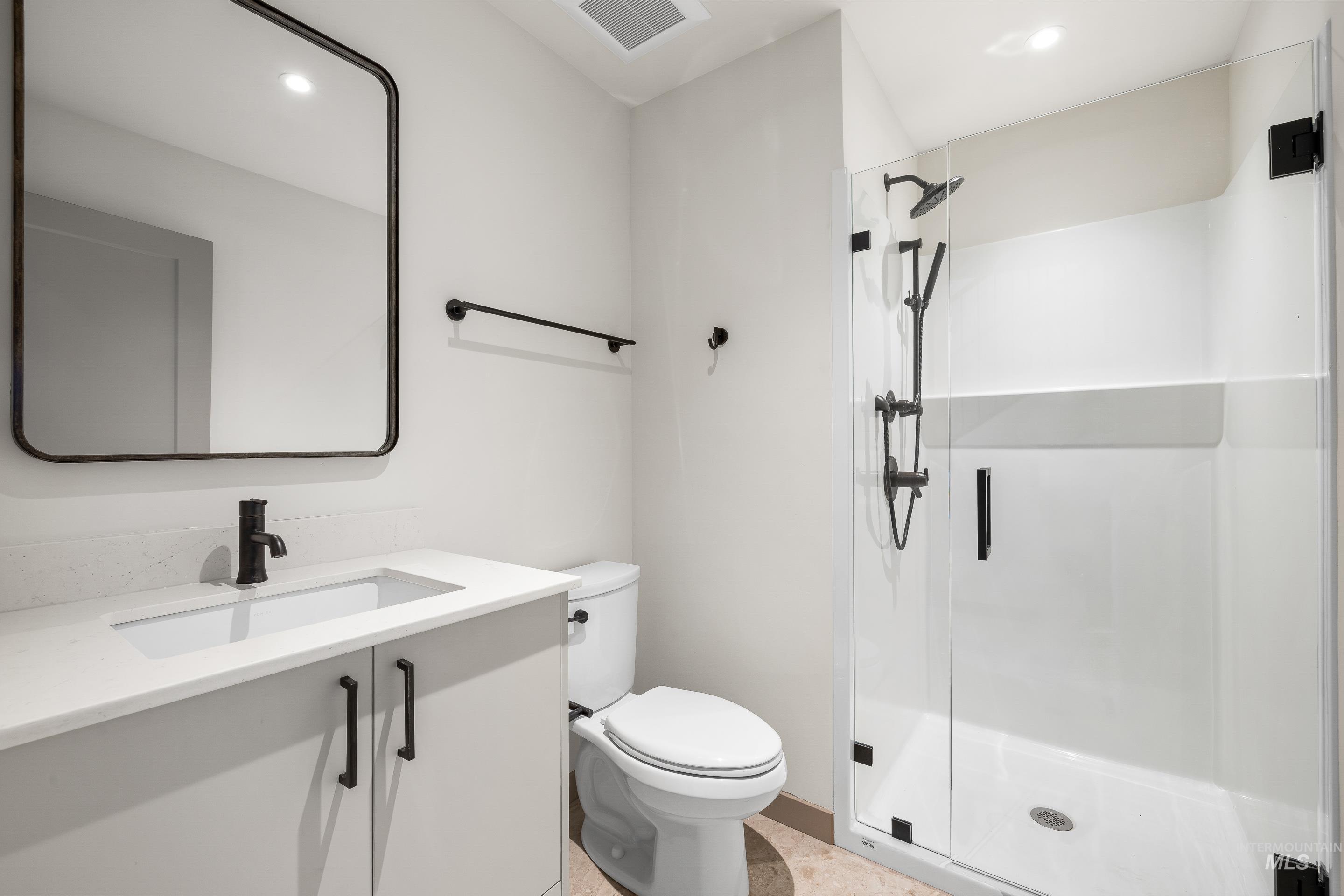 Full bath featuring vanity, a shower stall, and recessed lighting