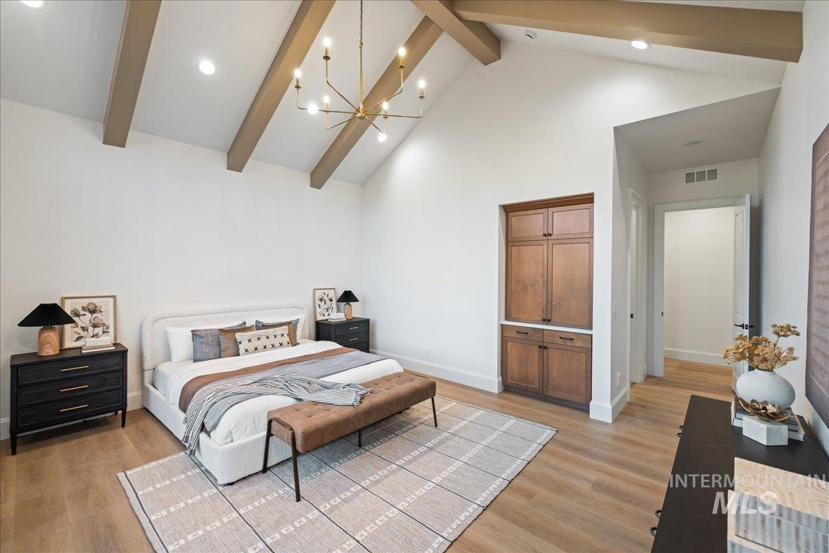 Bedroom featuring a chandelier, high vaulted ceiling, beam ceiling, light wood-type flooring, and recessed lighting