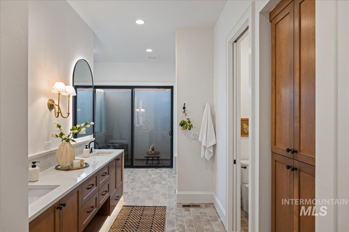 Full bathroom featuring double vanity, a stall shower, and recessed lighting