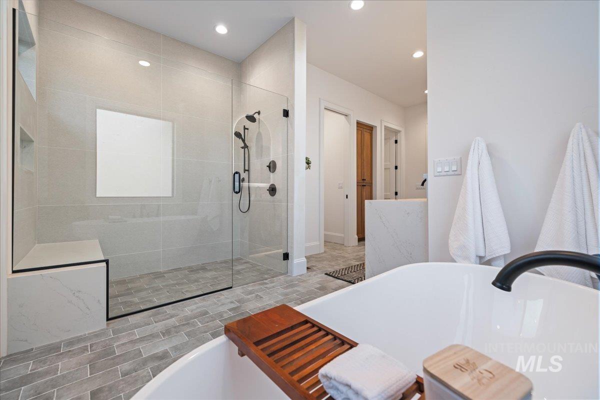 Bathroom with a freestanding tub, a shower stall, and recessed lighting