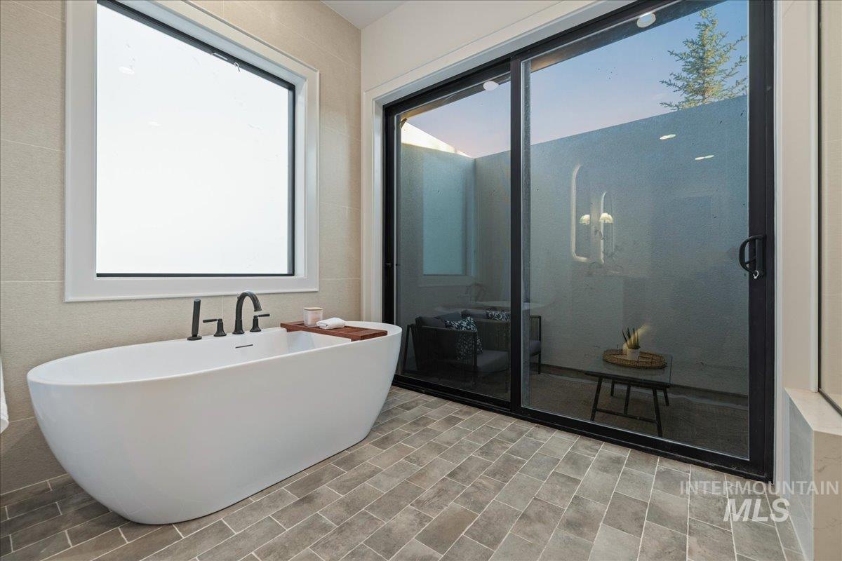 Bathroom featuring a soaking tub and a shower stall