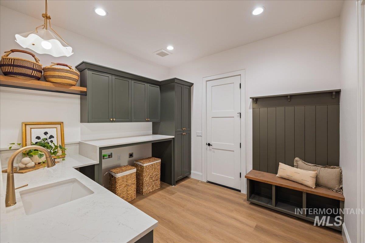 Kitchen featuring light wood finished floors, pendant lighting, recessed lighting, and light stone countertops