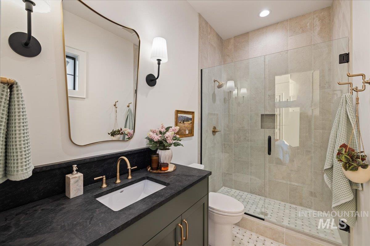 Full bathroom with vanity and a shower stall