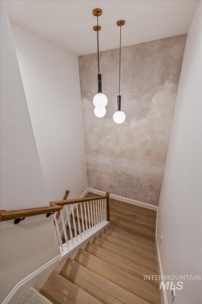 Staircase with baseboards and wood finished floors