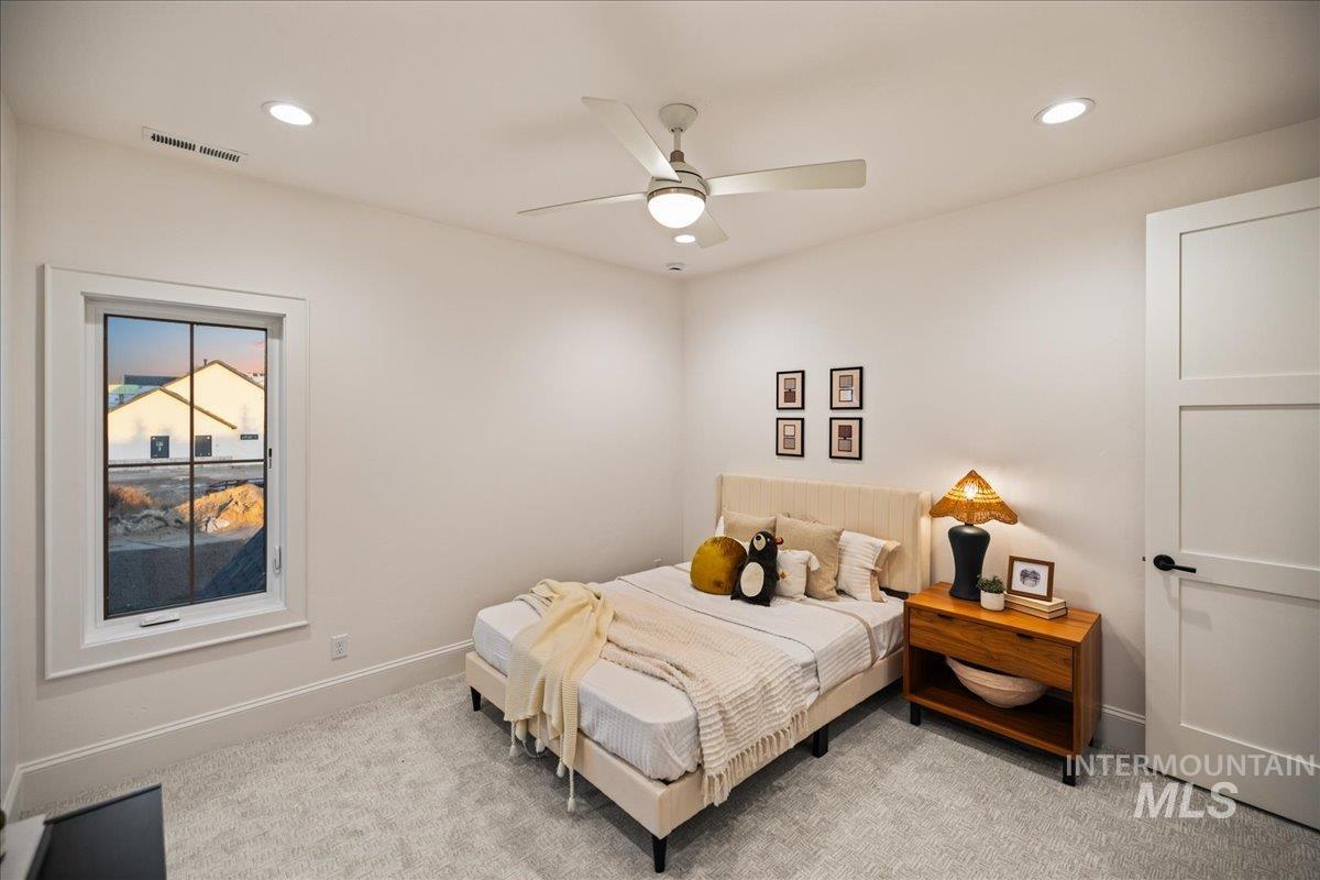 Bedroom featuring light colored carpet, ceiling fan, and recessed lighting