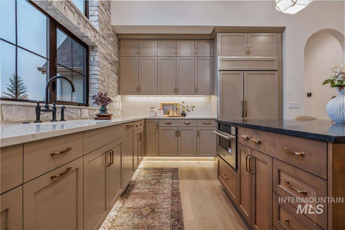 Kitchen with dark stone counters, plenty of natural light, and gray cabinetry