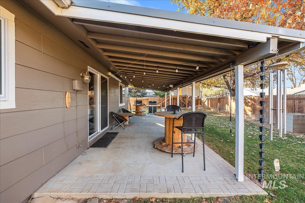 Fenced backyard featuring a patio area and grilling area