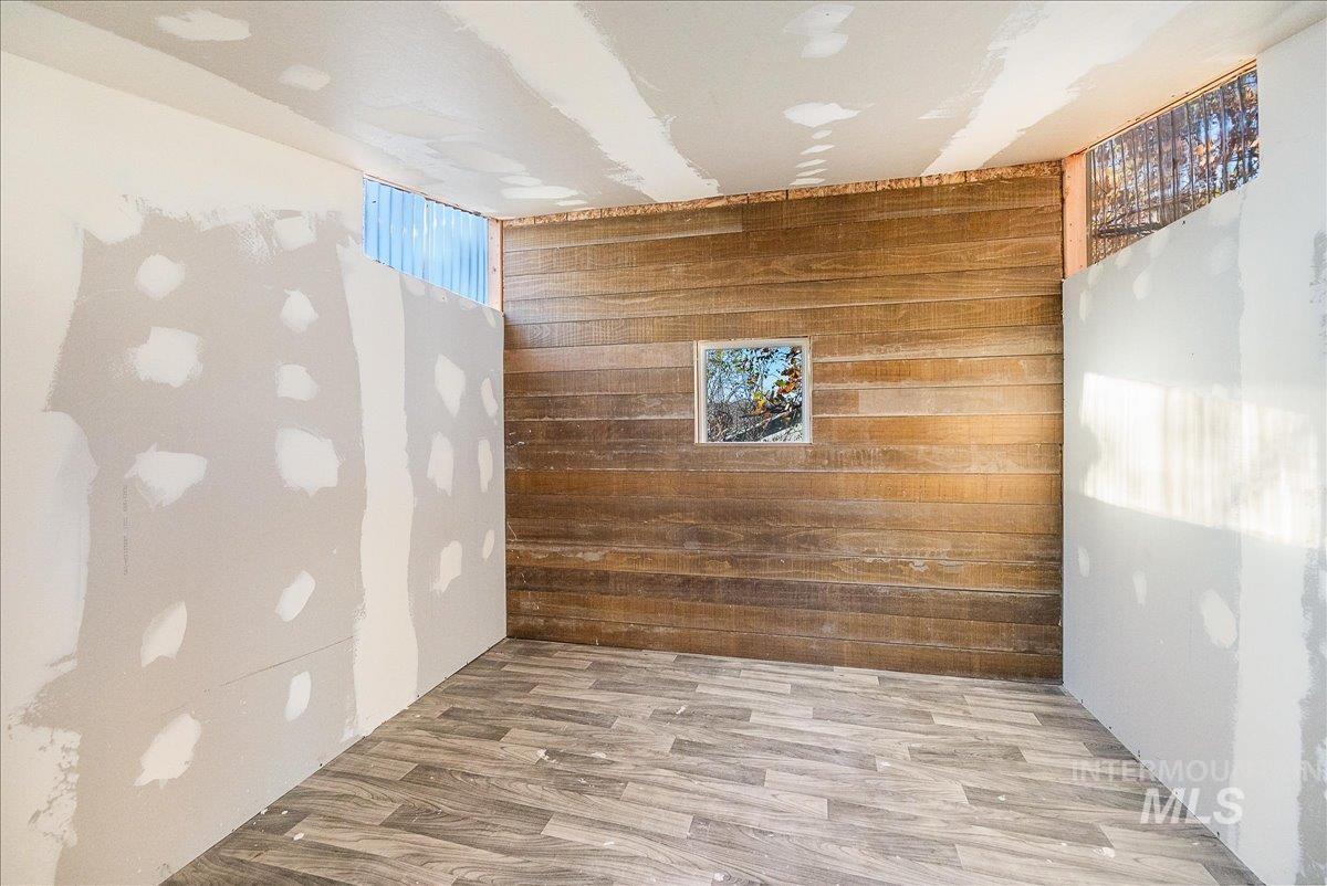 Empty room featuring wooden walls and wood finished floors