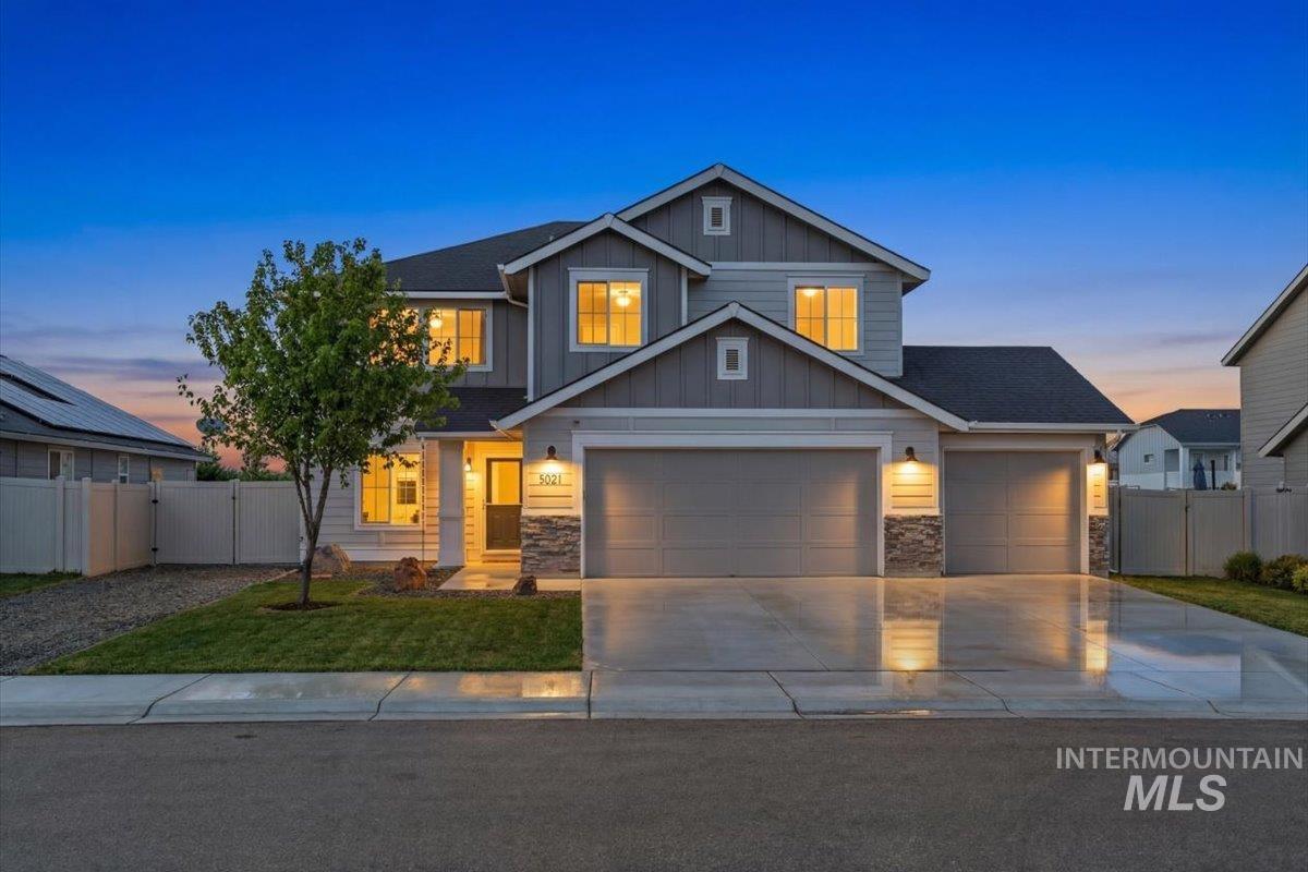 Craftsman-style home featuring concrete driveway, board and batten siding, stone siding, and an attached garage