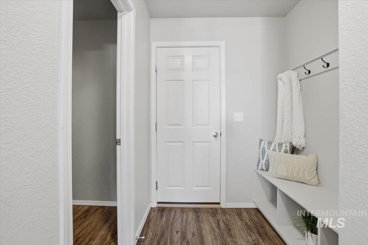 Mudroom with dark wood-style floors and a textured wall
