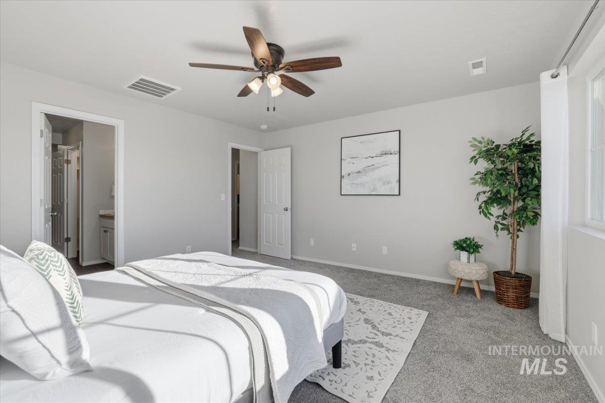Bedroom with carpet, ceiling fan, and ensuite bathroom